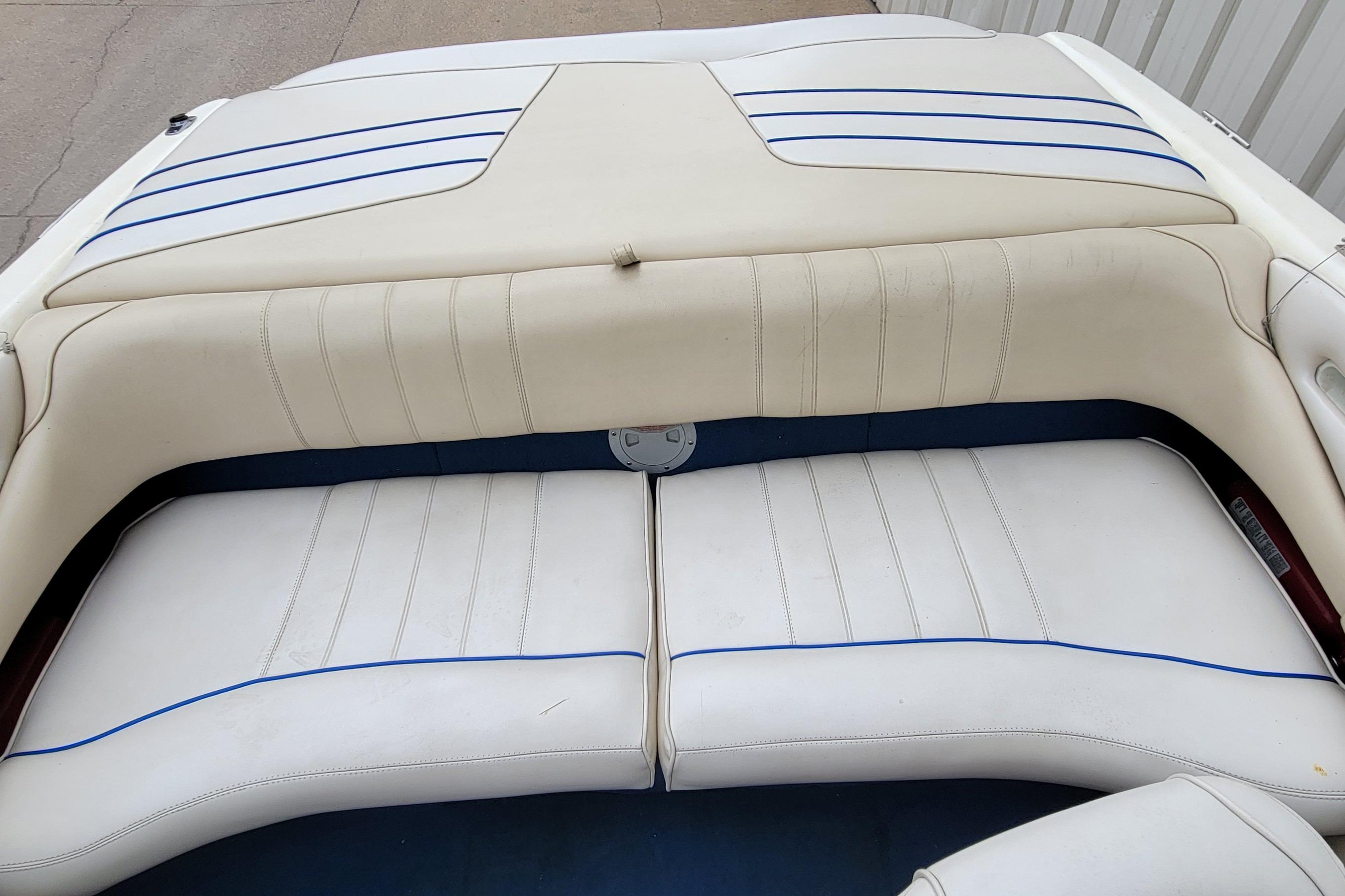 1994 Sea Ray 180 Bow Rider interior with white and blue cushioned seating.