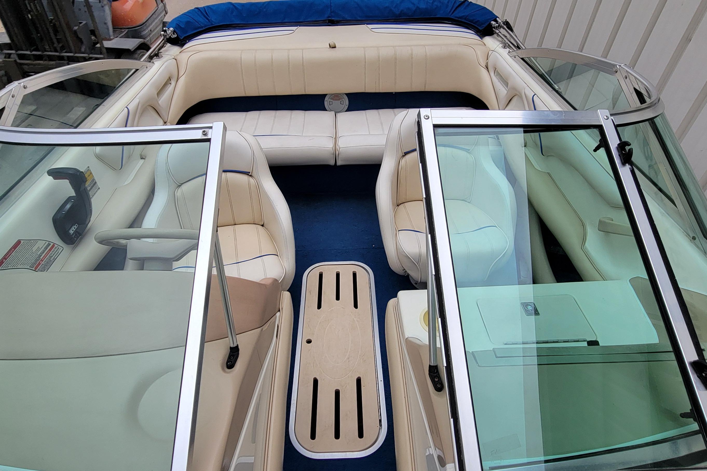 1994 Sea Ray 180 Bow Rider interior with beige seating and blue carpet.