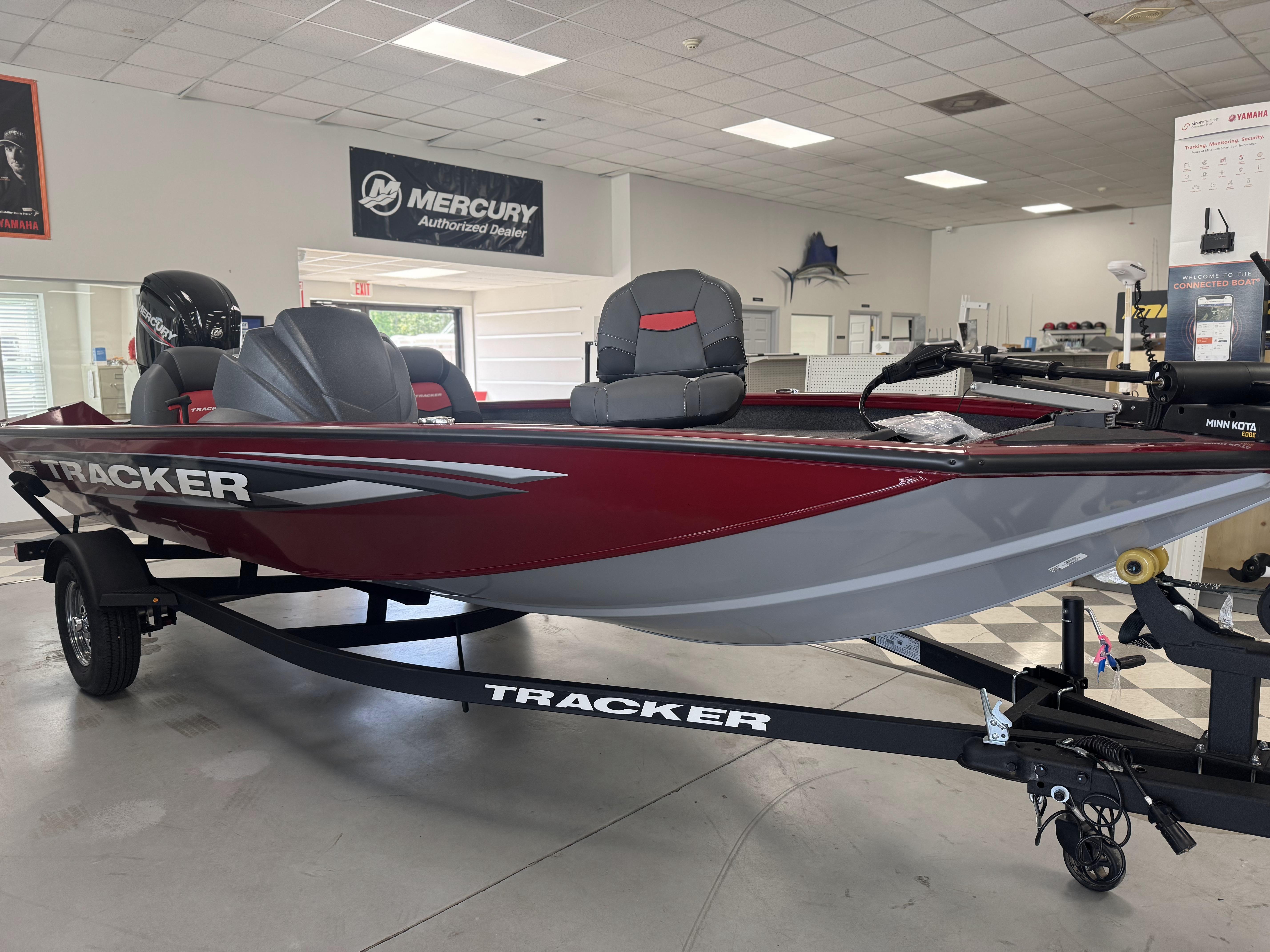 2025 Tracker Pro Team 175 boat in showroom, featuring red and gray design.