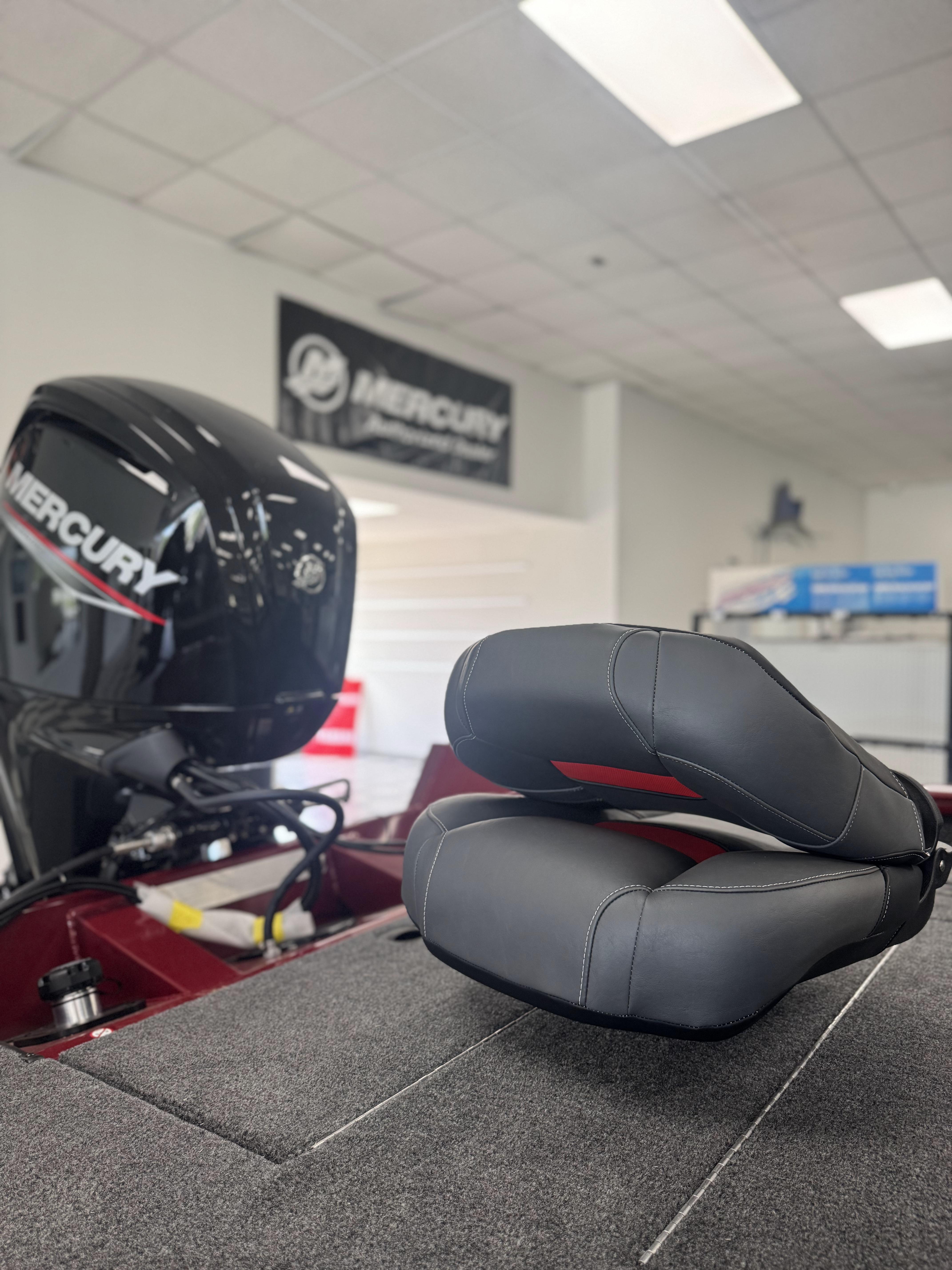2025 Tracker Pro Team 175 boat with Mercury engine and cushioned seats in showroom.