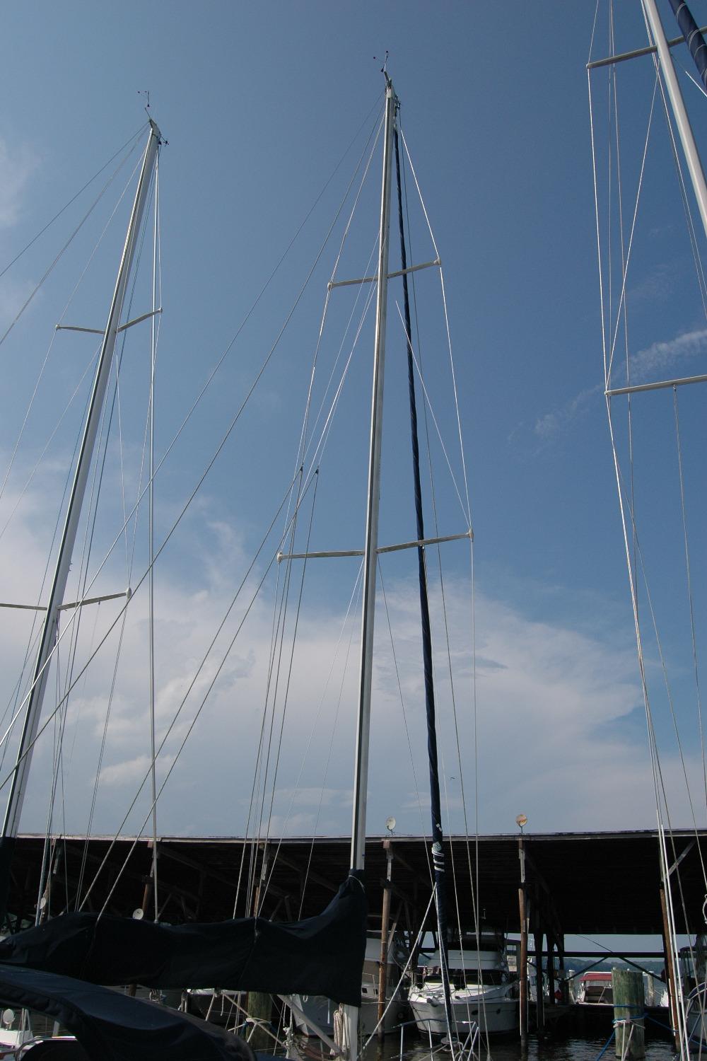Tall masts of a 1988 Sabre 38 MkII sailboat against a clear blue sky.
