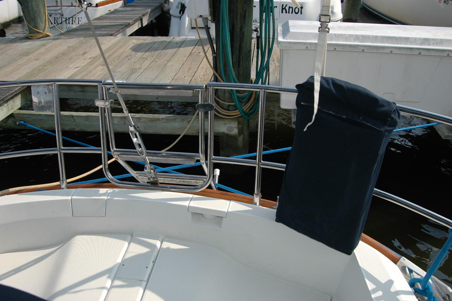 1988 Sabre 38 MkII sailboat stern with stainless steel railings and dock in background.