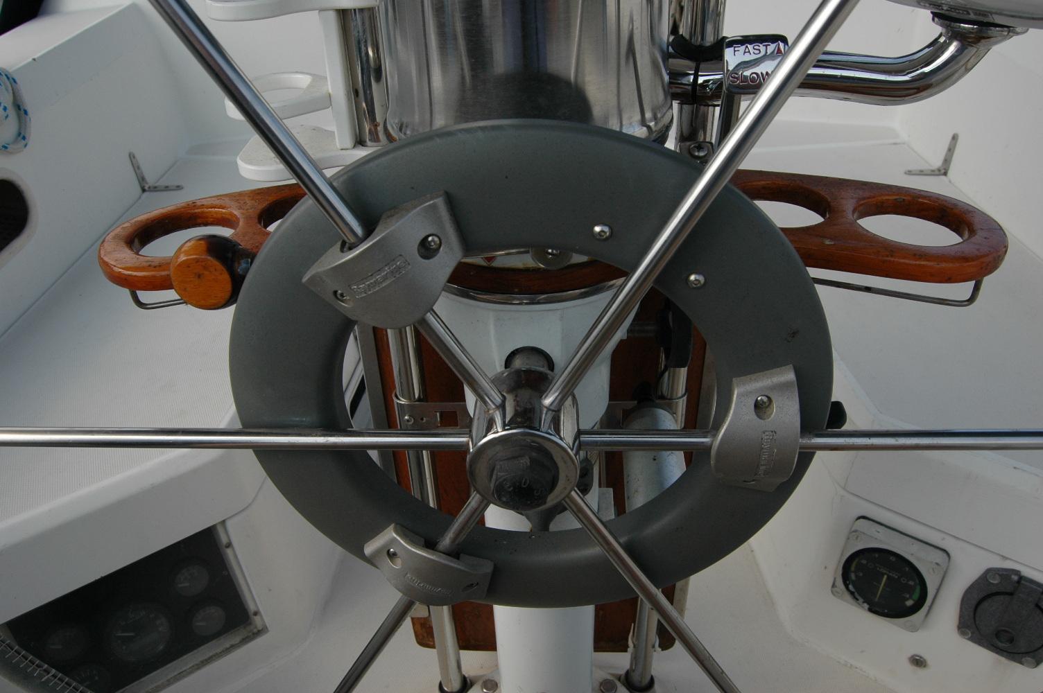 Steering wheel of a 1988 Sabre 38 MkII sailboat, featuring stainless steel and wood accents.