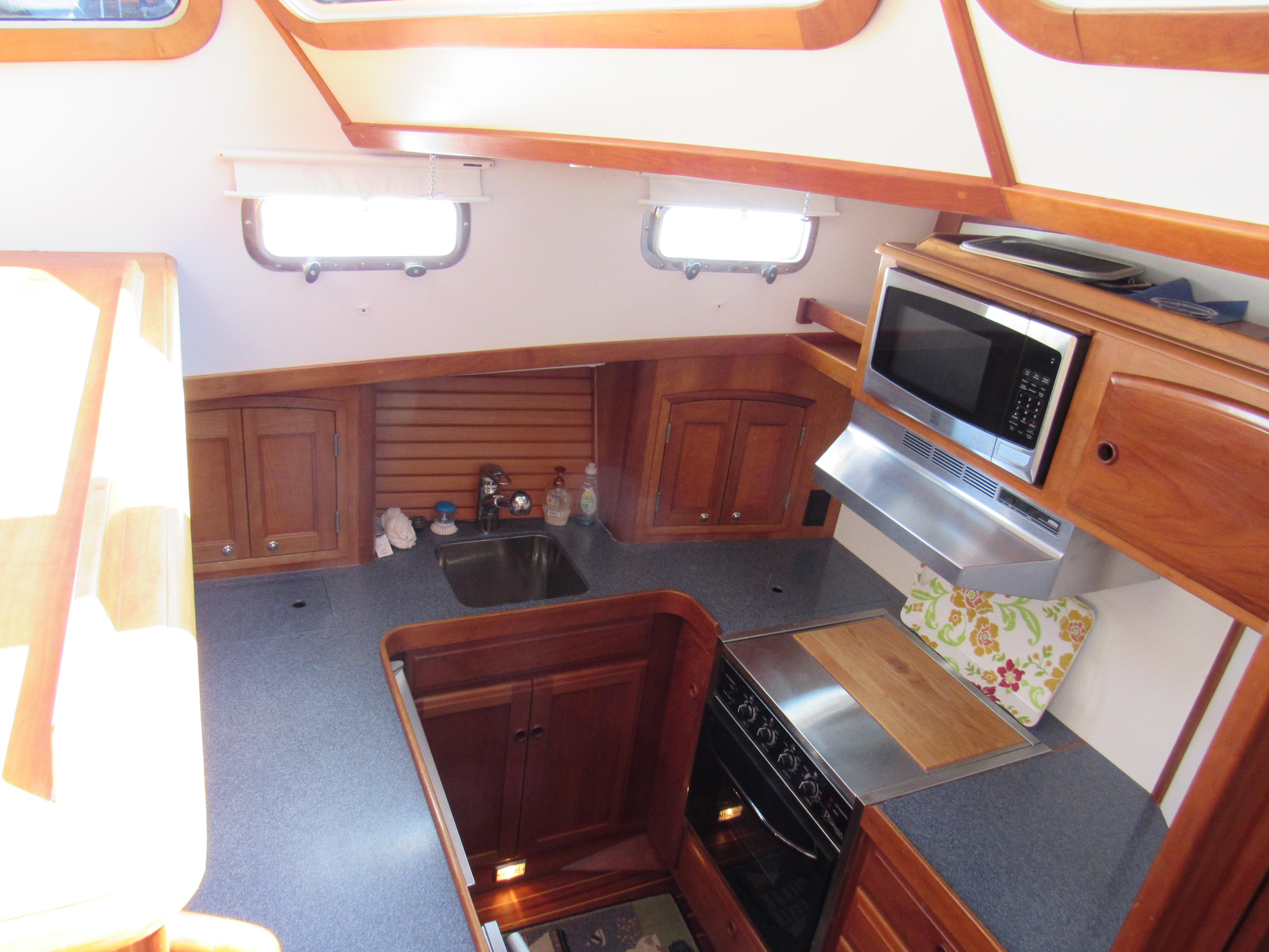 Sabre-Sabreline 47 1999-CANDY O RI-US-1999 Sabreline 47 yacht kitchen with wood cabinetry, microwave, and stove.-9522318 | Thumbnail