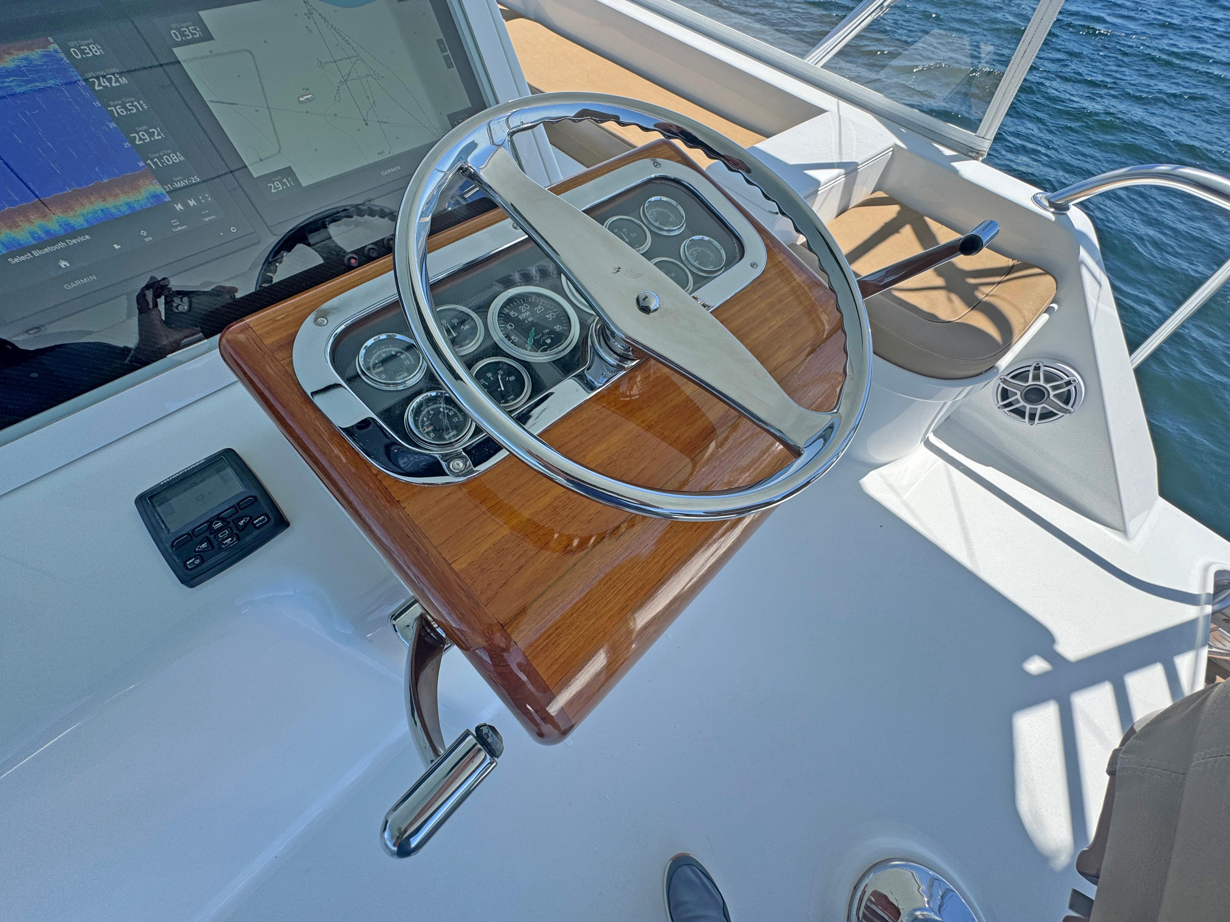 Jim Smith-65 Convertible 2000-PIER PRESSURE SC-US-Steering wheel of a 2000 Jim Smith 65 Convertible boat with wooden dashboard.-9833594 | Thumbnail
