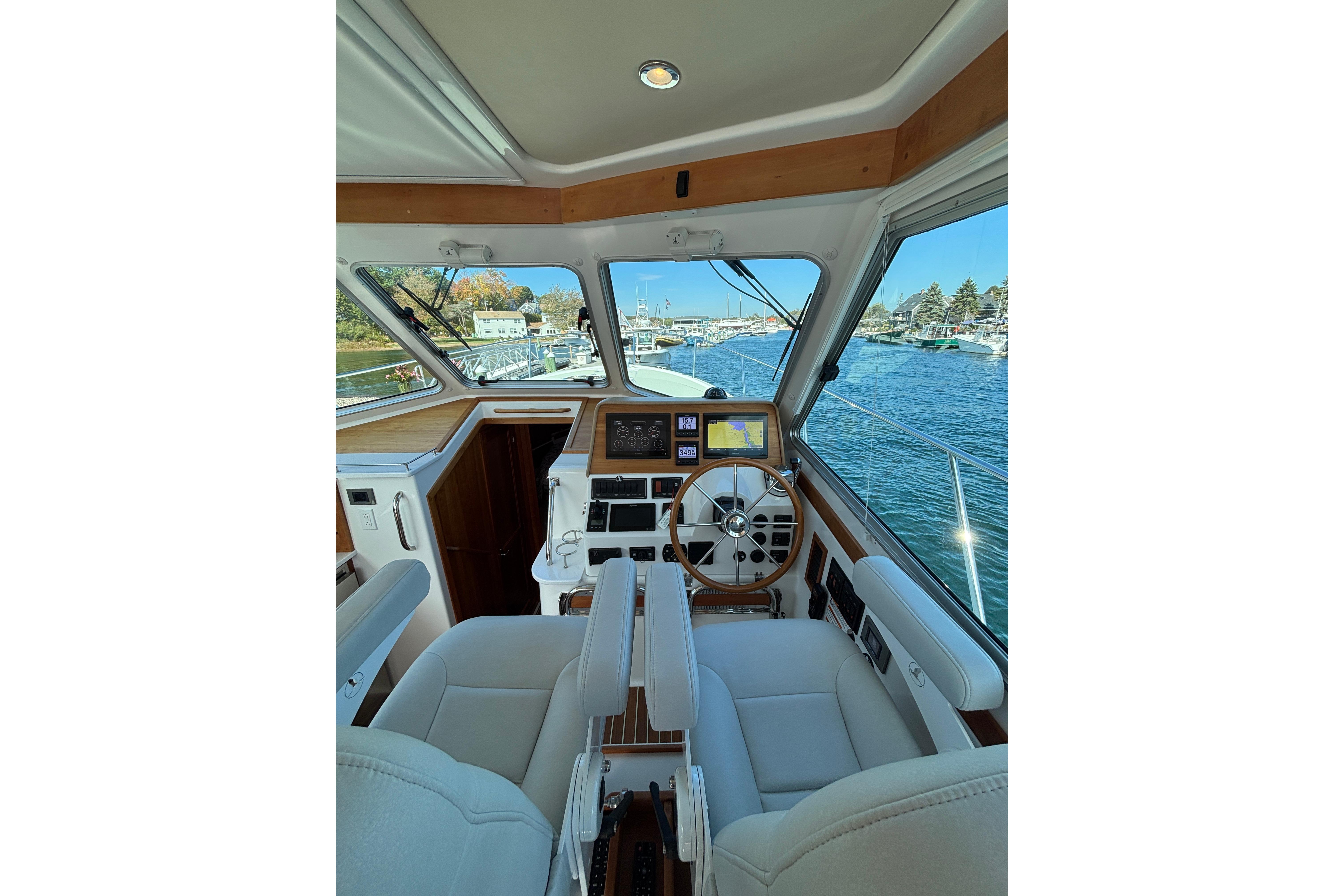 Interior view of 2020 Back Cove 37 yacht helm with navigation equipment and waterfront scenery.