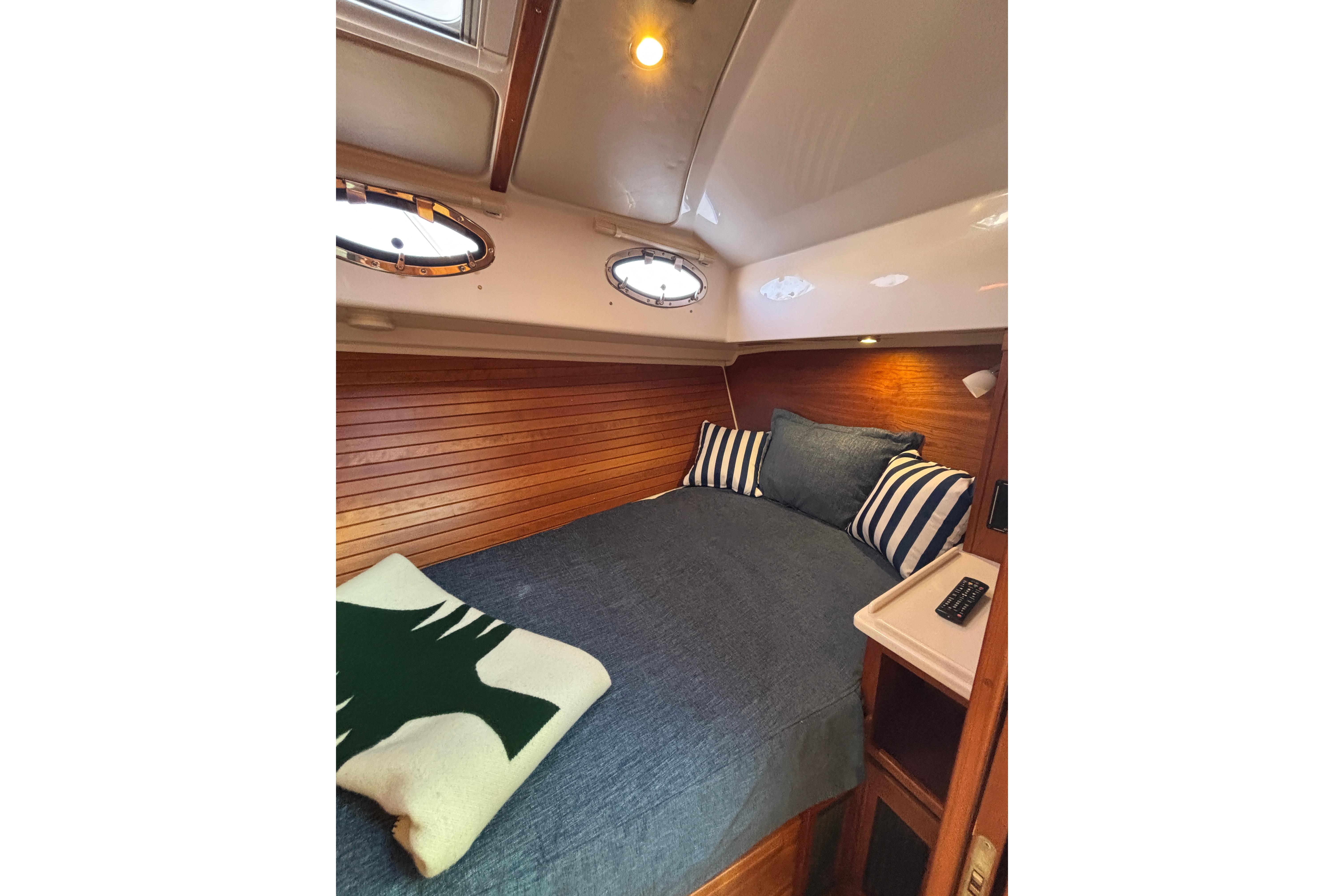 Cozy cabin interior of 2020 Back Cove 37 yacht with striped pillows and wooden paneling.