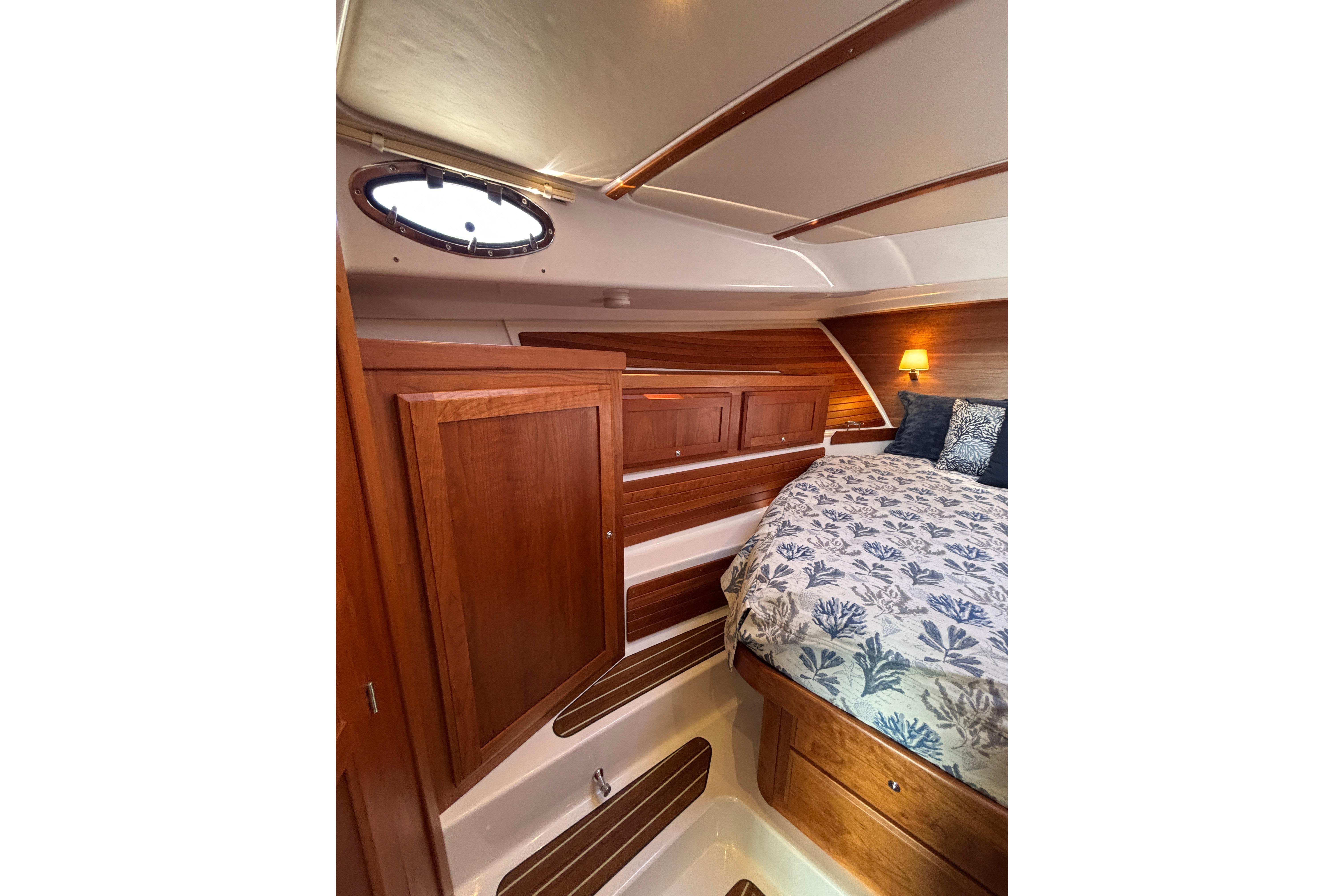 Luxurious cabin interior of 2020 Back Cove 37 yacht with wood finish and cozy bedding.
