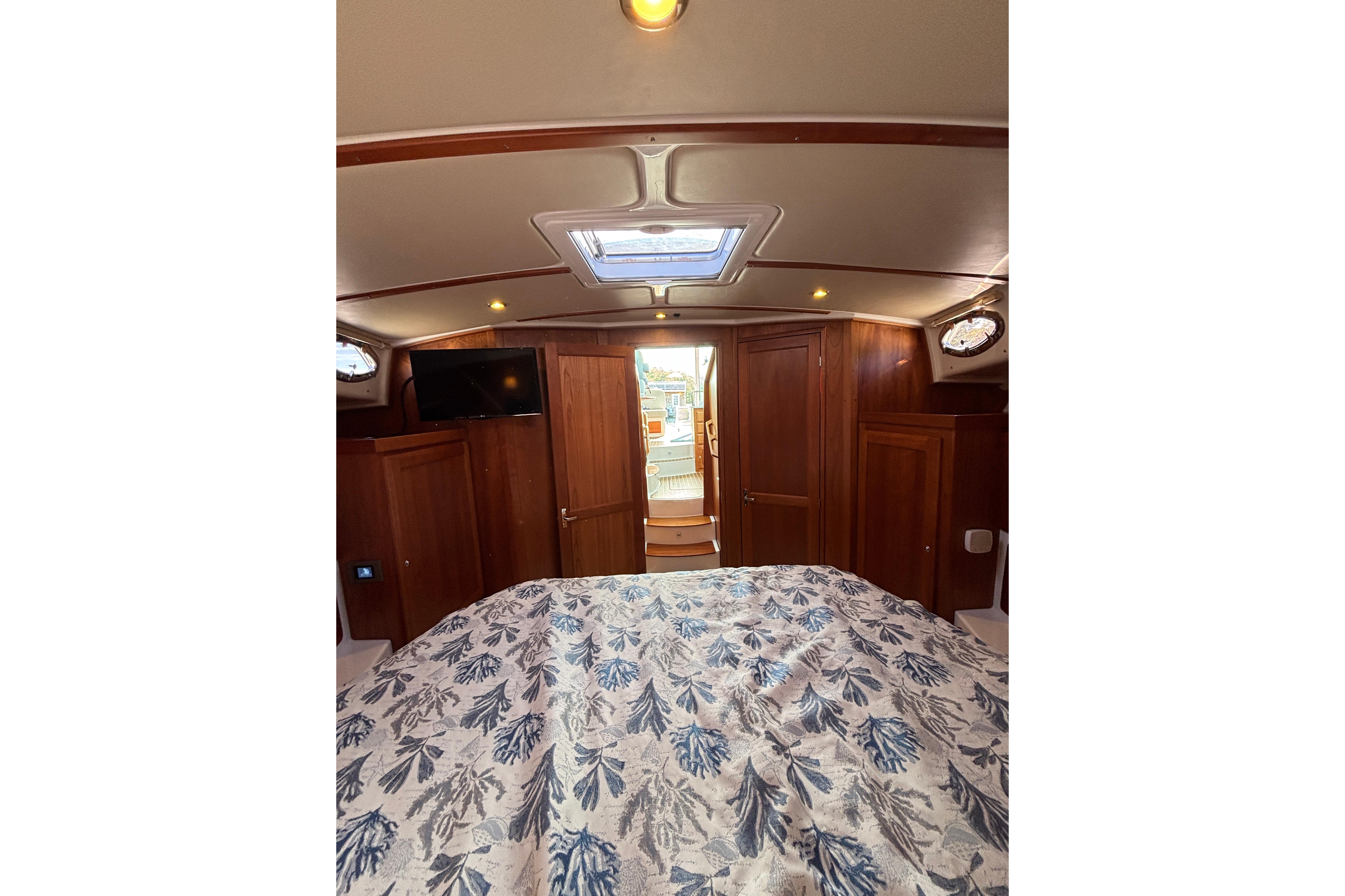 Cozy cabin interior of 2020 Back Cove 37 yacht with wood paneling and floral bedding.