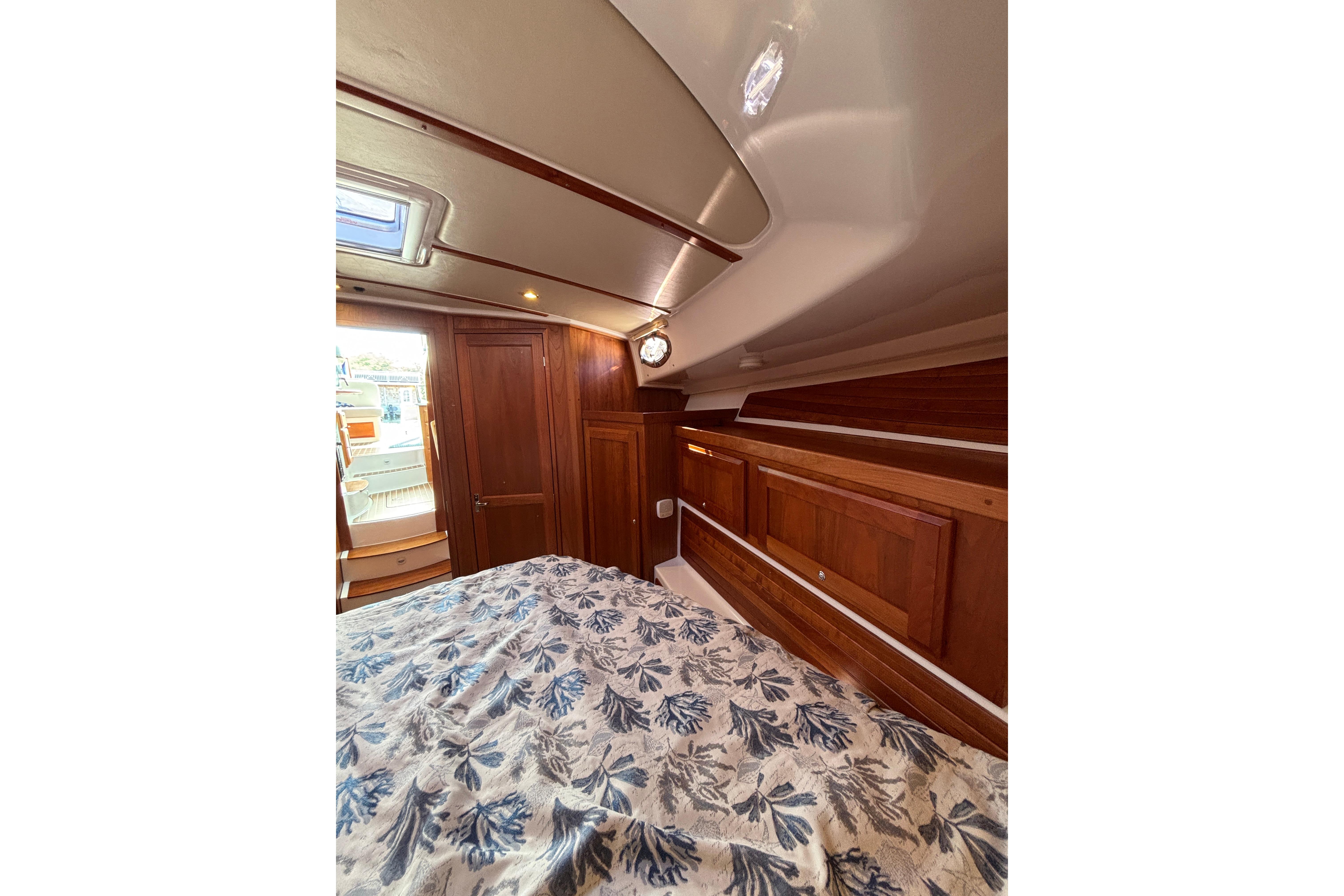 2020 Back Cove 37 cabin interior with wood paneling and floral bedding.