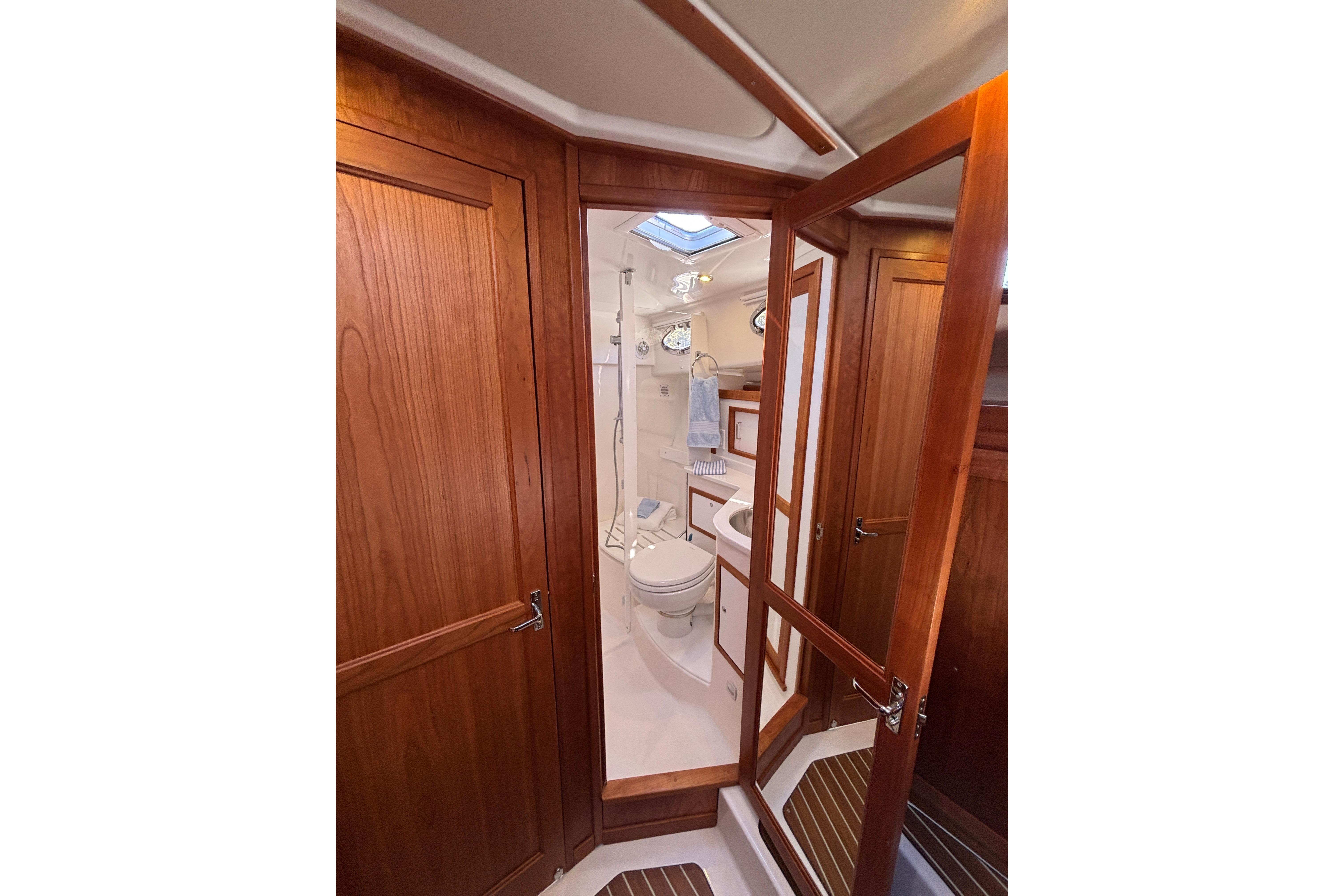 Luxurious bathroom interior of 2020 Back Cove 37 yacht with wooden cabinetry and modern fixtures.