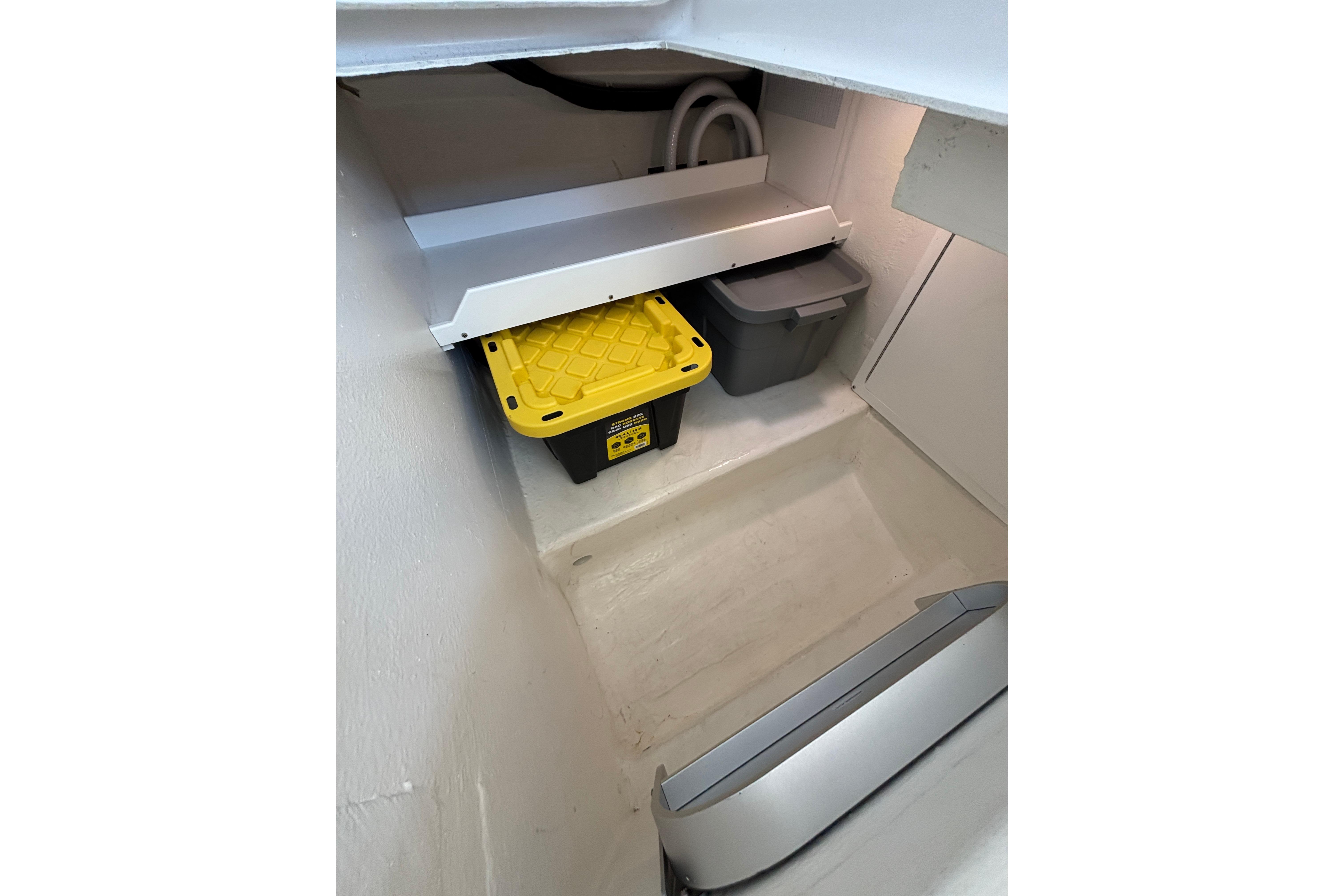 Storage compartment in a 2020 Back Cove 37 boat, featuring organized bins and clean interior.