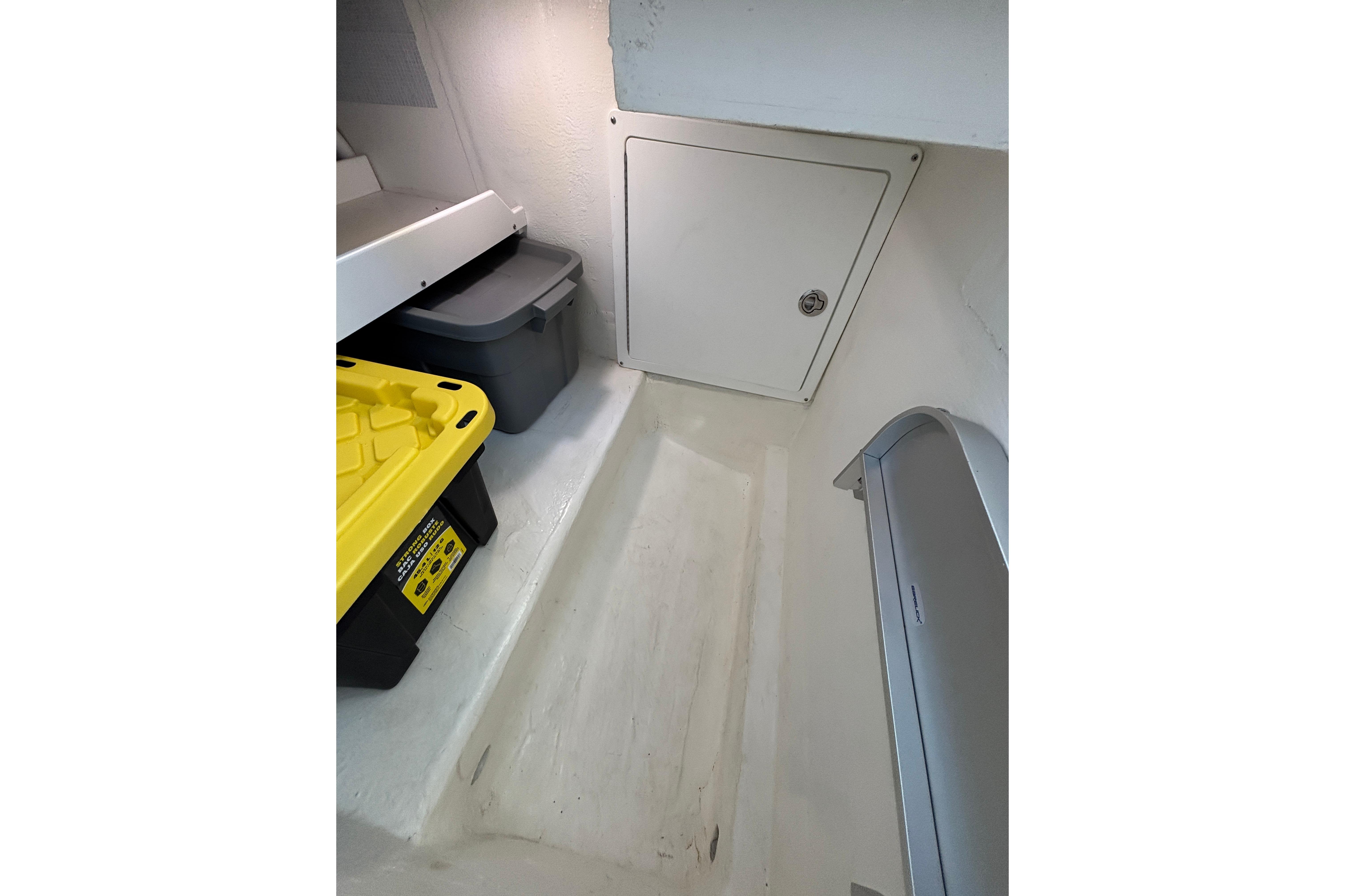 Storage area in 2020 Back Cove 37 boat with bins and access panel.