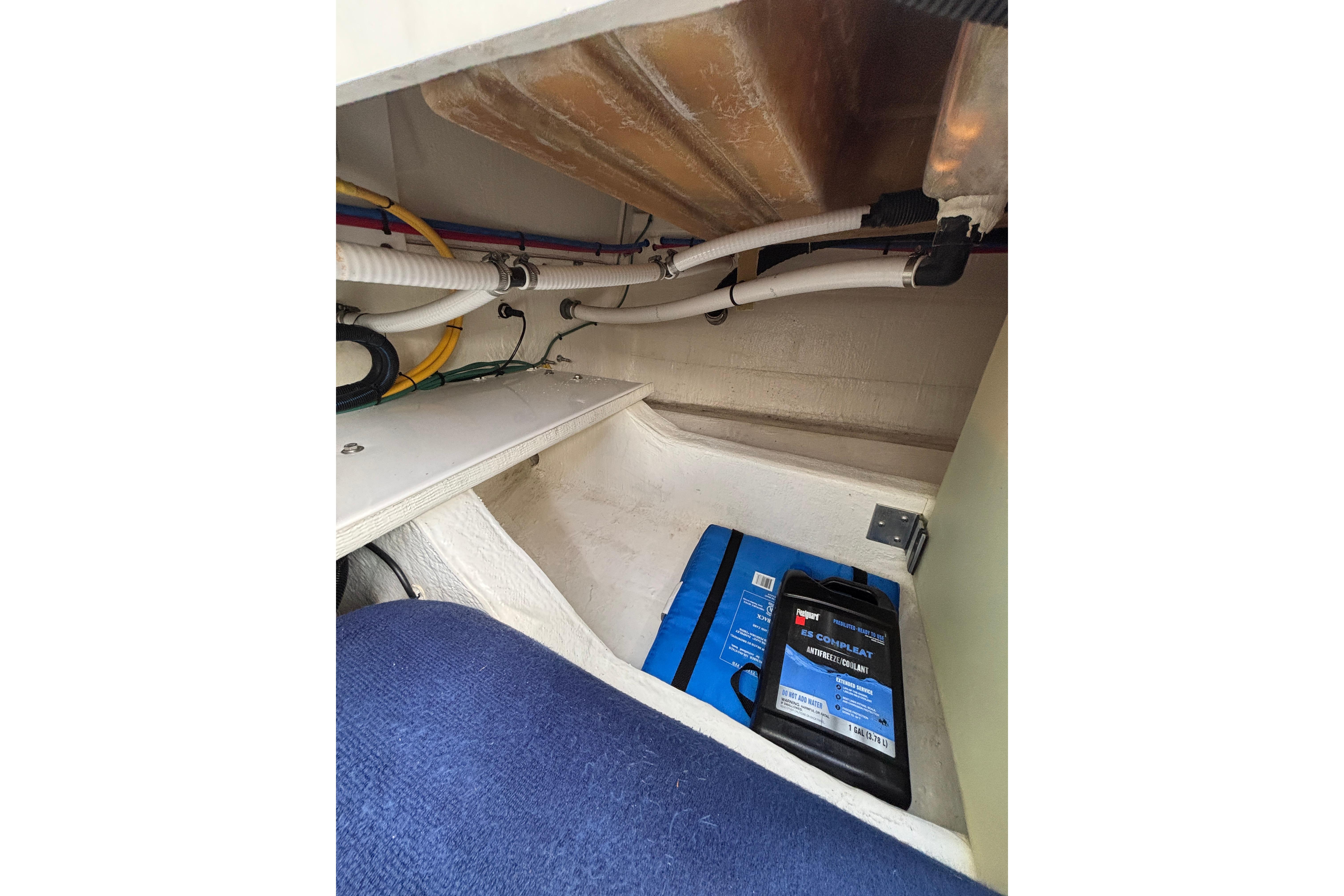 2020 Back Cove 37 boat interior showing storage compartment with cables and antifreeze container.