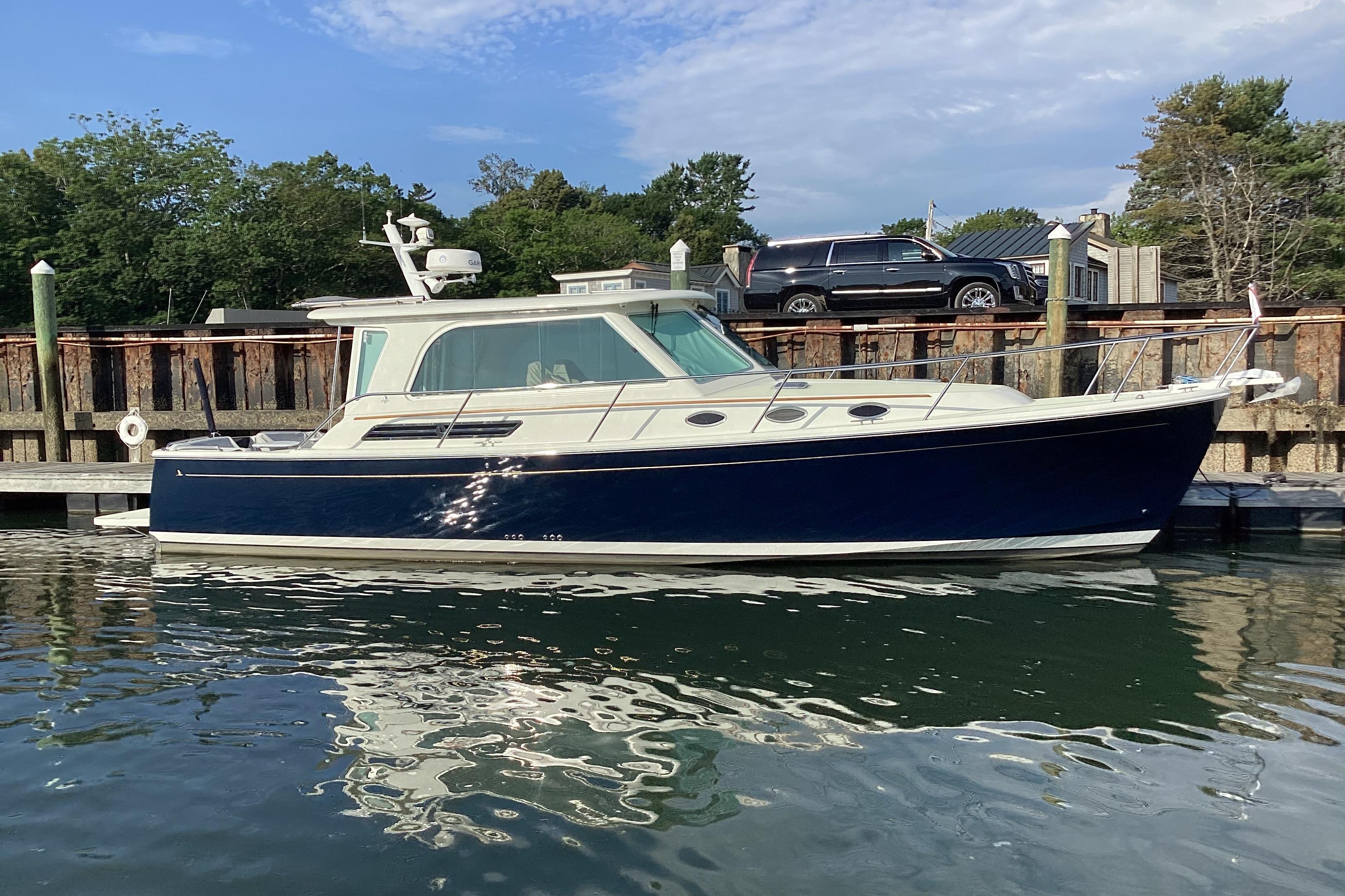 2020 Back Cove 37 boat docked in a marina, reflecting on calm water.