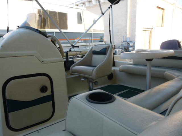 Interior of a 2000 SeaArk Sunstar 21 boat with seating and steering console.