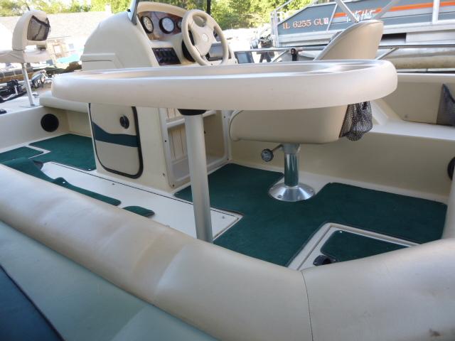Interior of 2000 SeaArk Sunstar 21 boat with steering wheel and seating area.