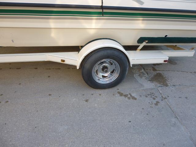 Trailer wheel of a 2000 SeaArk Sunstar 21 boat on pavement.