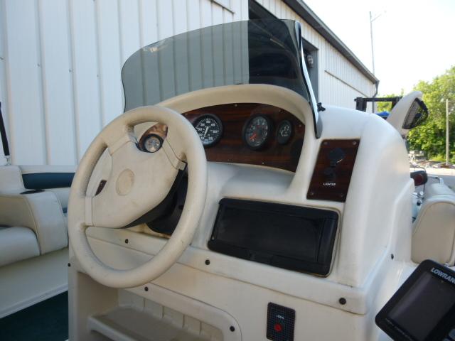 Steering console of a 2000 SeaArk Sunstar 21 boat with gauges and controls.