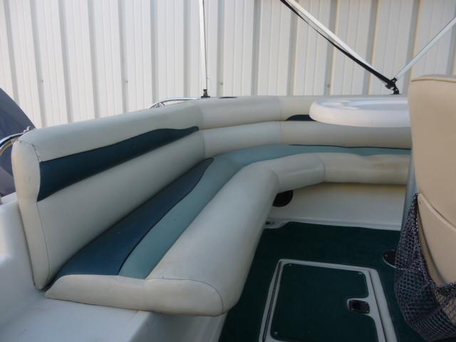 Interior seating of a 2000 SeaArk Sunstar 21 boat with white and green upholstery.