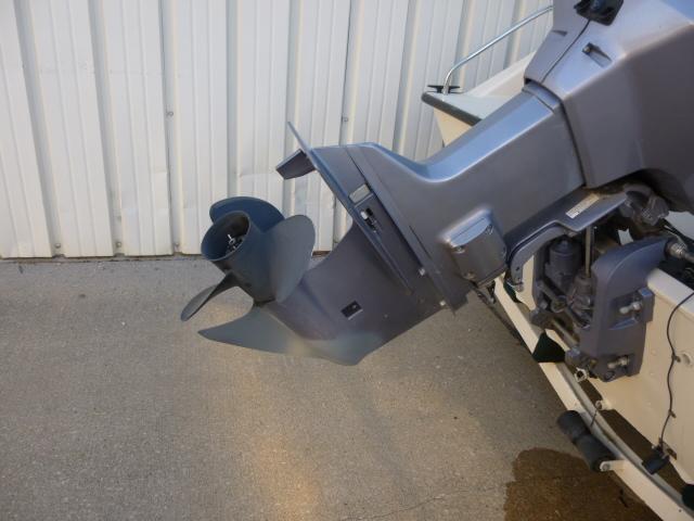 Outboard motor of a 2000 SeaArk Sunstar 21 boat, displayed against a metal wall.
