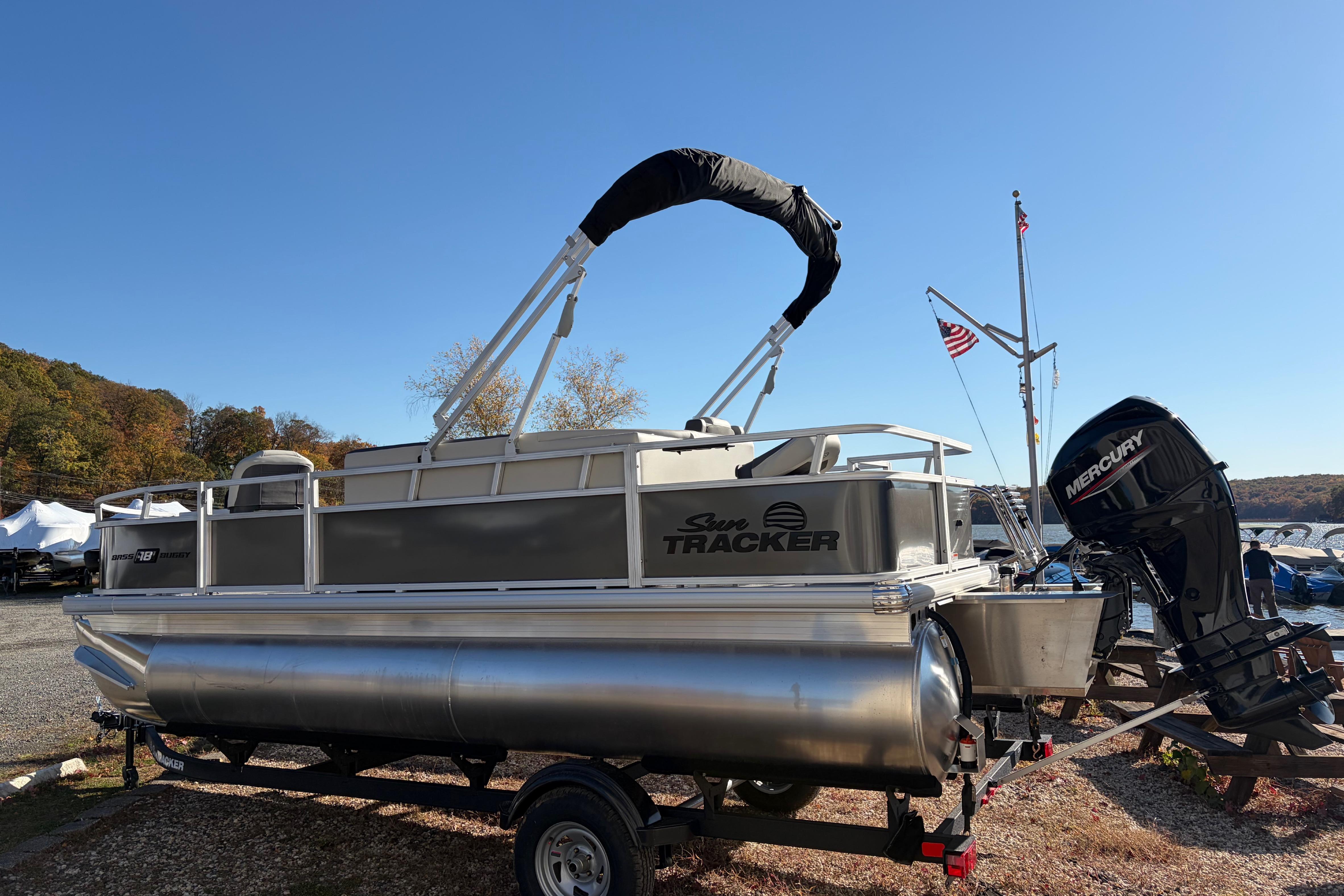 2026 Sun Tracker Bass Buggy 18 DLX pontoon boat with Mercury outboard motor.