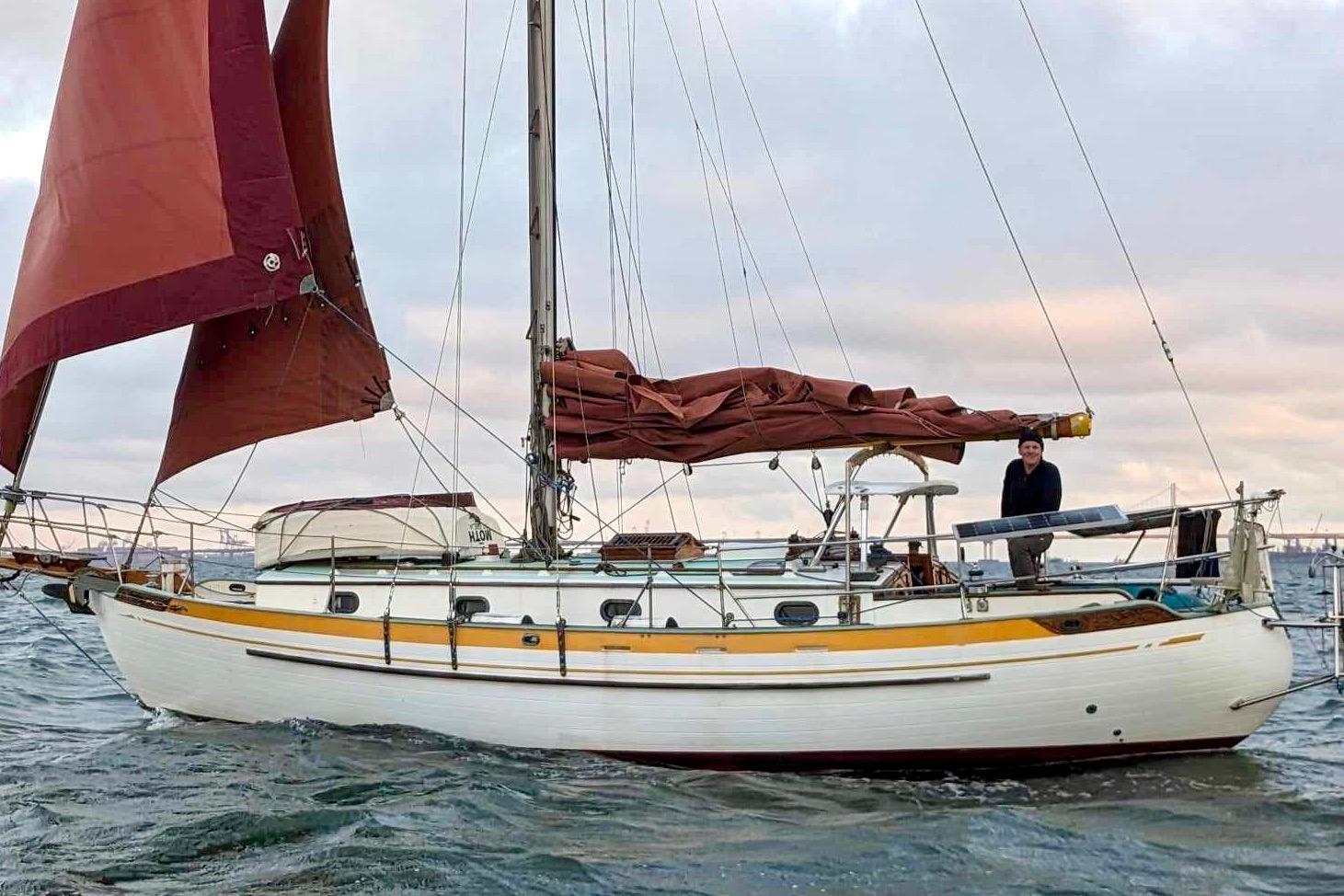 1978 Tayana 37 sailboat with red sails on open water.