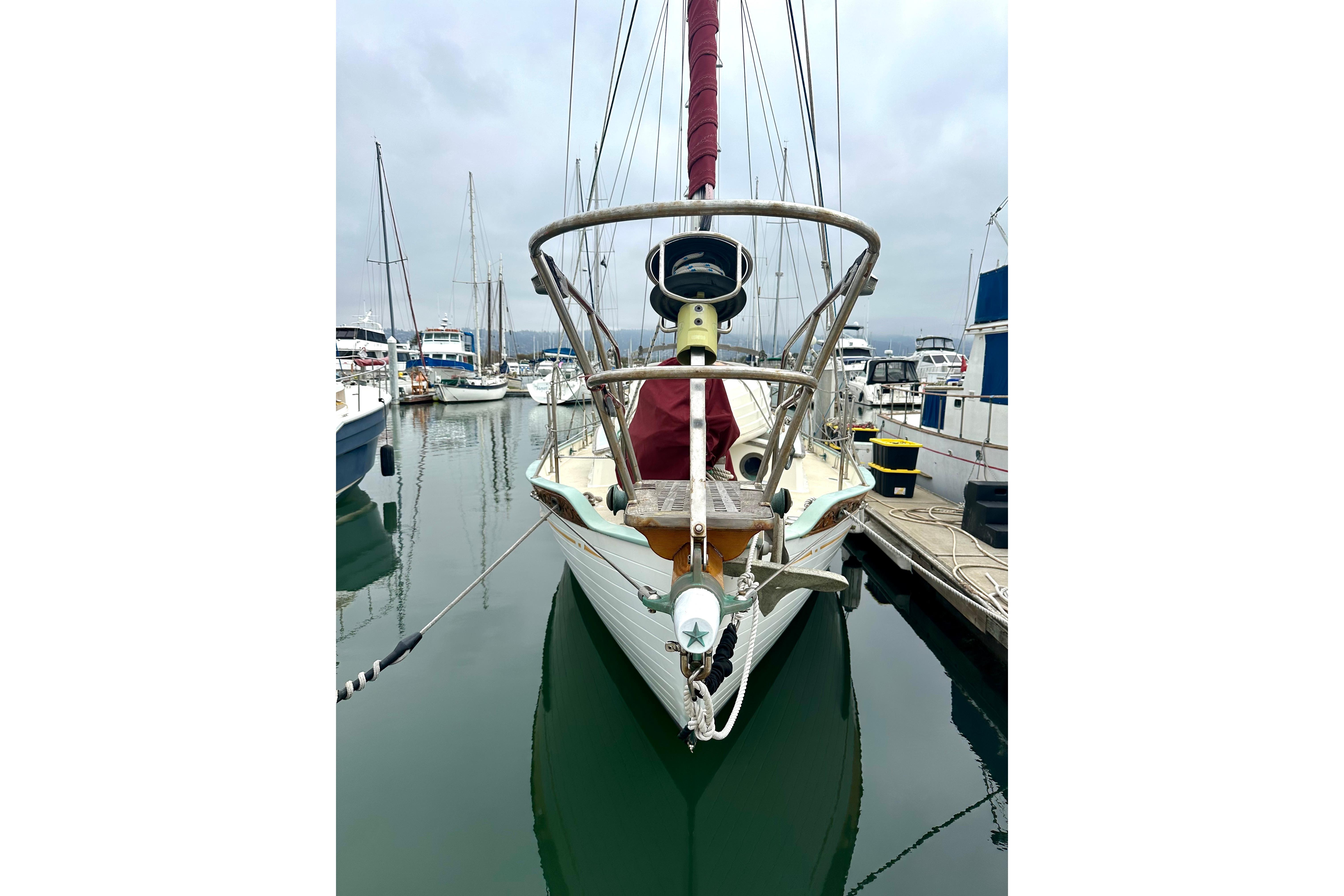 1978 Tayana 37 sailboat docked in a marina, front view with masts and rigging.