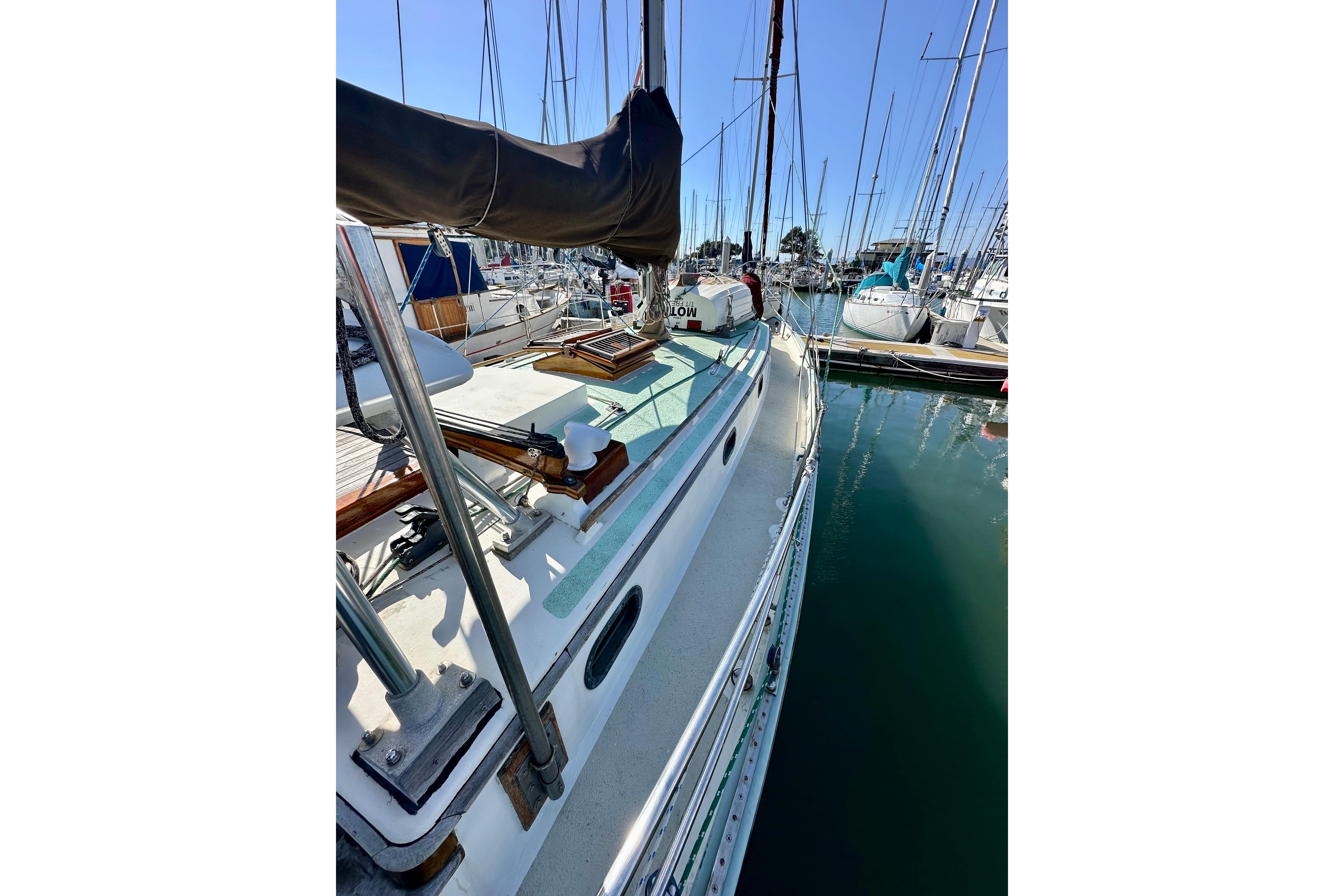 1978 Tayana 37 sailboat docked in a marina, surrounded by other boats.