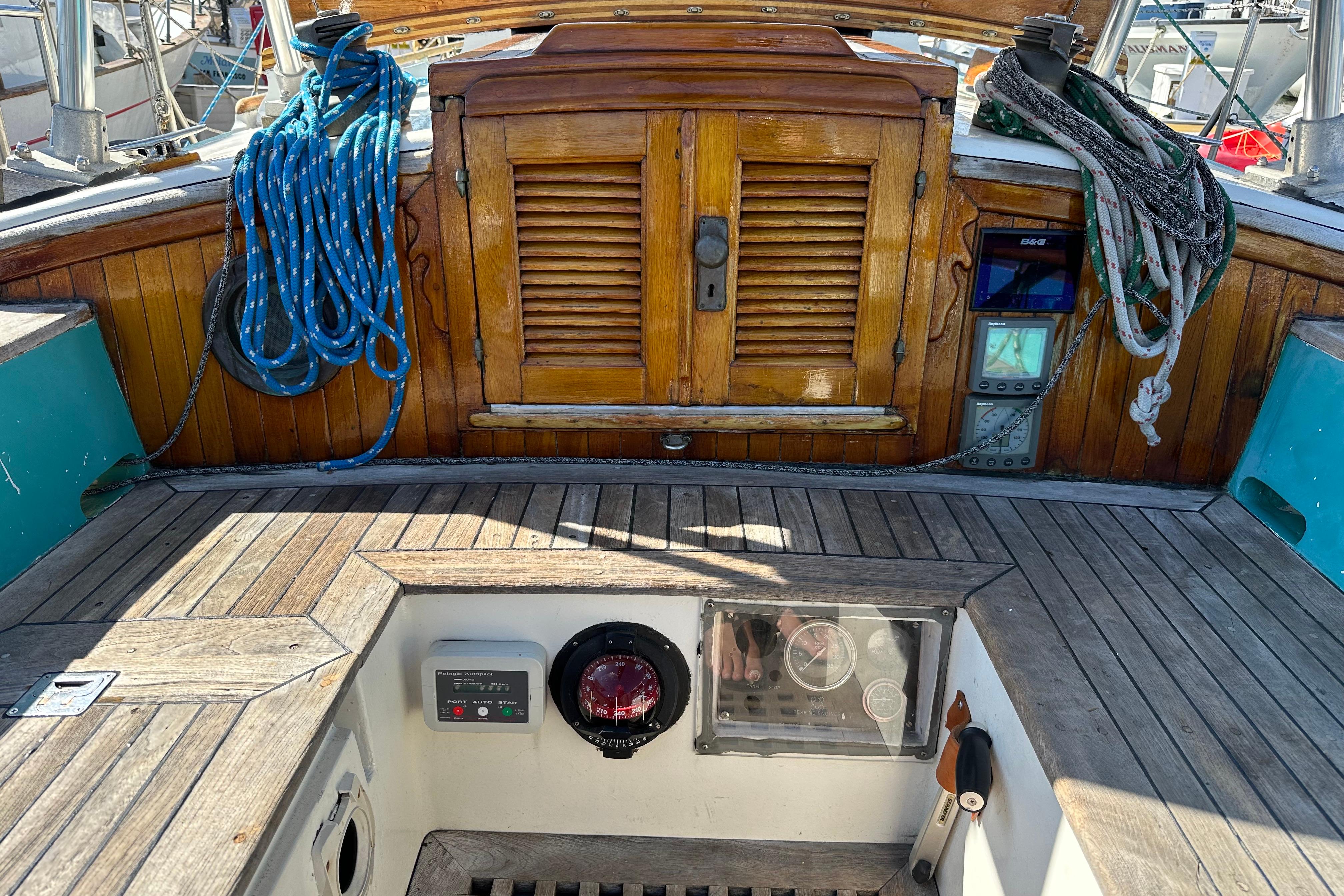 Cockpit of 1978 Tayana 37 sailboat with wooden details and nautical equipment.