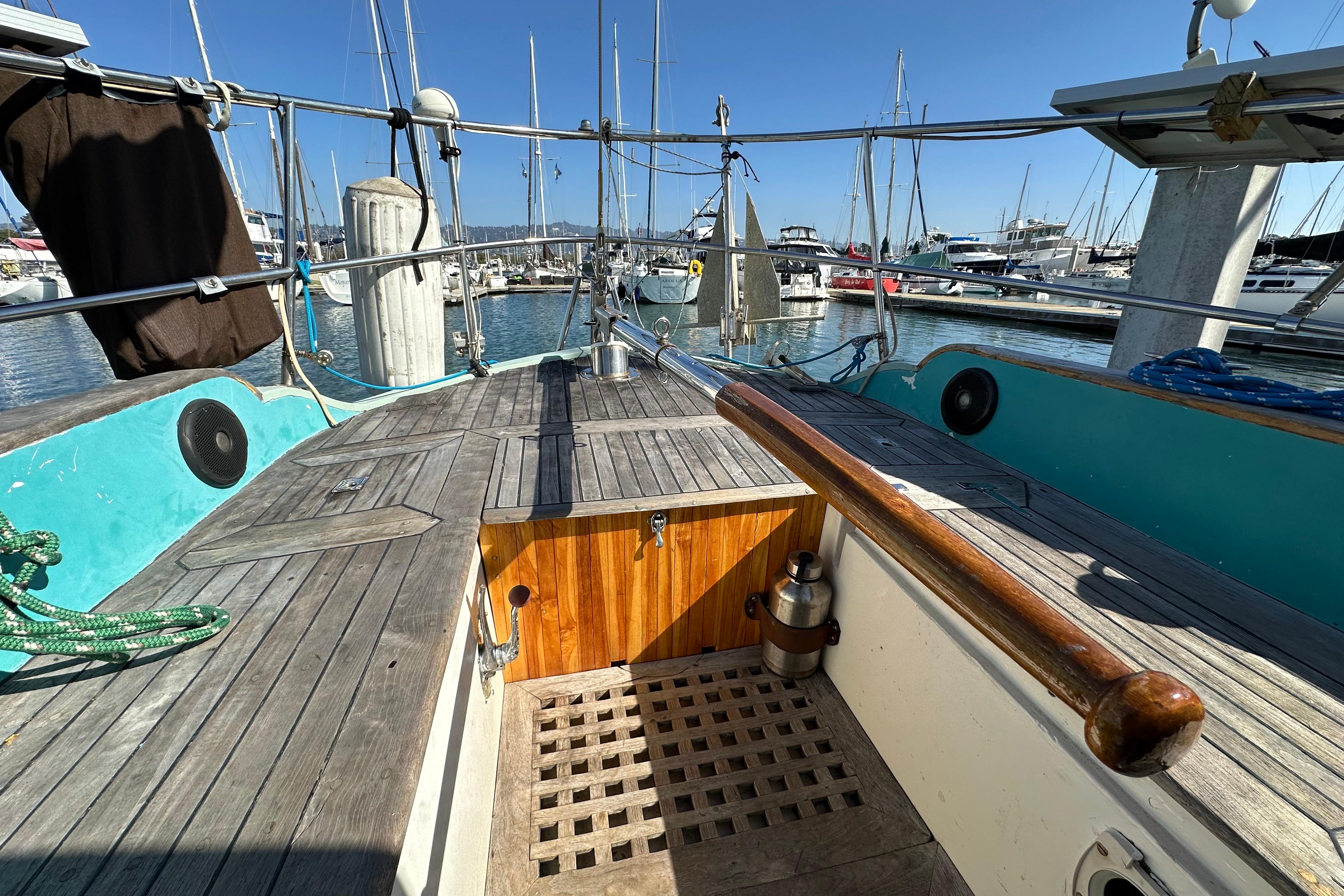 1978 Tayana 37 sailboat cockpit with wooden deck, docked in a marina.