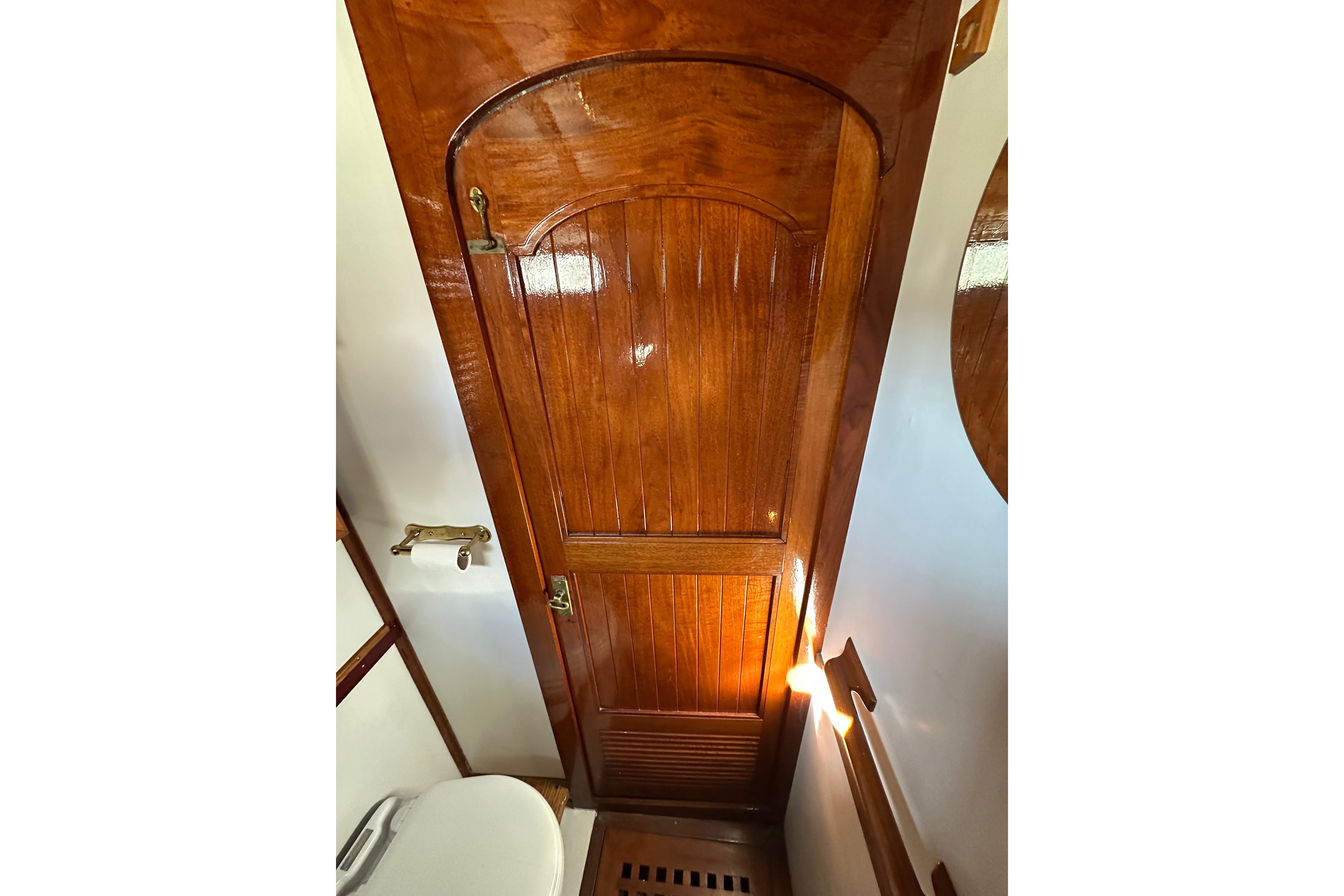 Wooden door and toilet in 1978 Tayana 37 yacht interior.