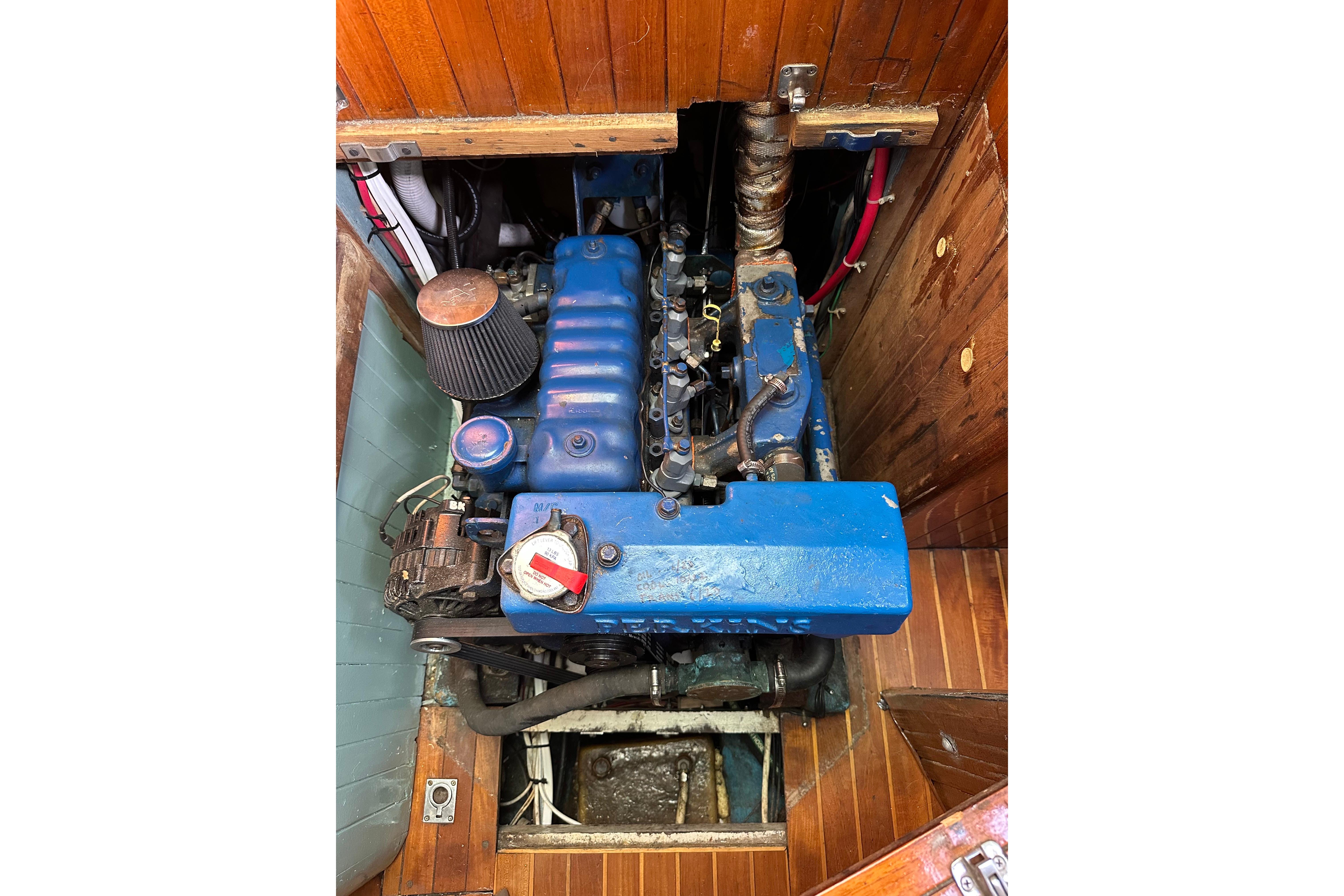 Engine compartment of a 1978 Tayana 37 sailboat, featuring a blue marine engine.
