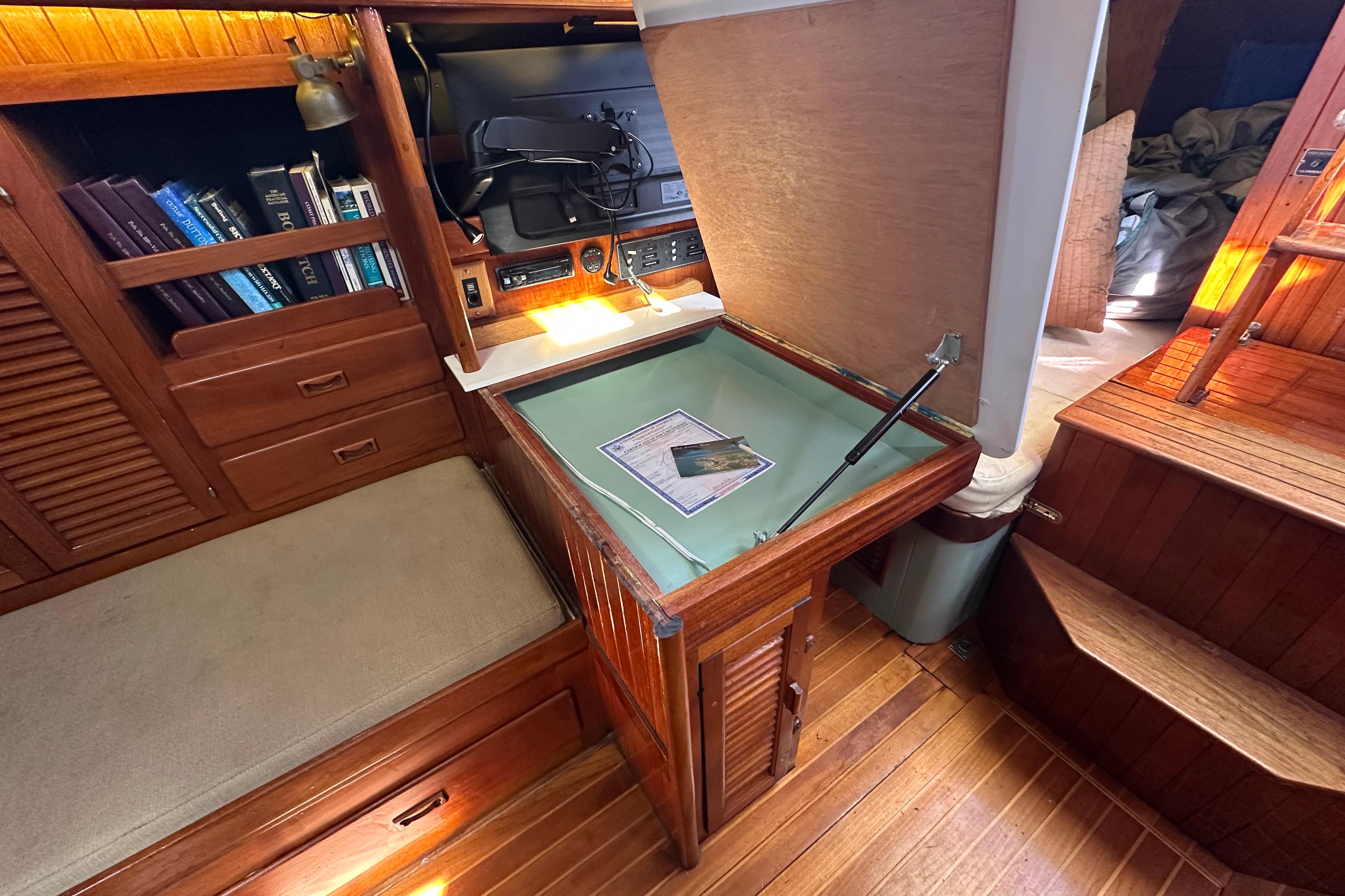 Interior of 1978 Tayana 37 sailboat with navigation station and wooden cabinetry.