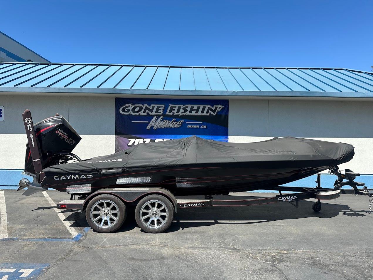 2024 Caymas XS 20 boat covered on trailer, parked outside a building.