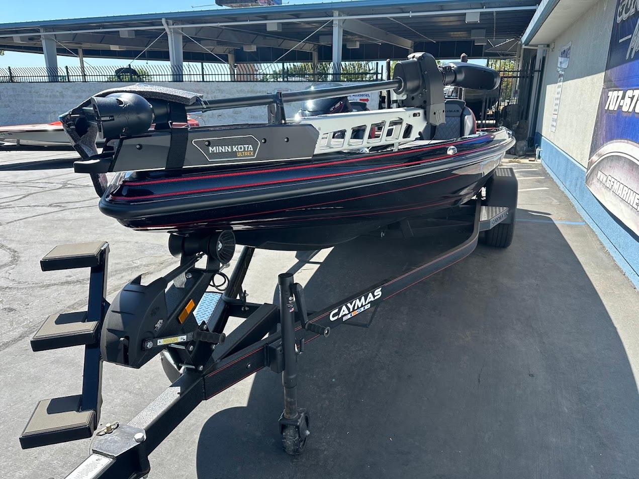 2024 Caymas XS 20 boat on trailer with Minn Kota motor, parked outdoors.
