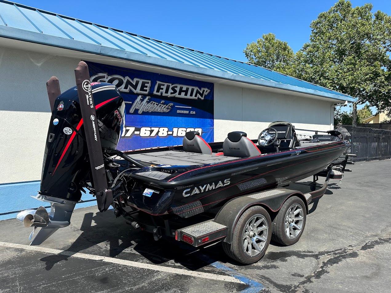 2024 Caymas XS 20 boat on trailer, parked outside a marine shop.