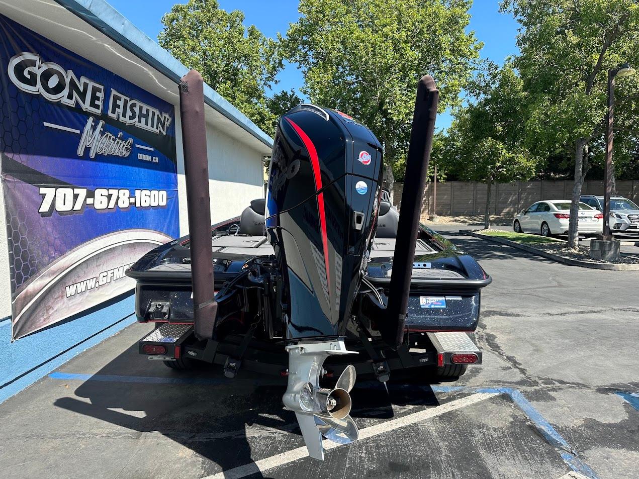 2024 Caymas XS 20 boat with powerful outboard motor at dealership parking lot.