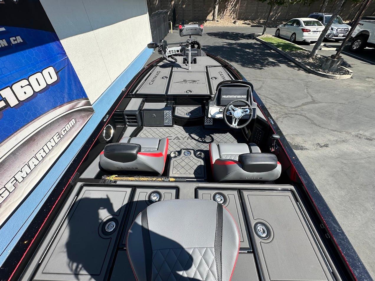2024 Caymas XS 20 boat interior with steering wheel and seating, parked outdoors.