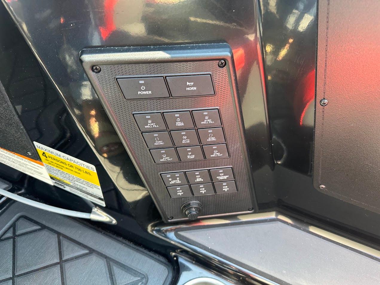 Control panel of 2024 Caymas XS 20 boat with various switches and capacity label.
