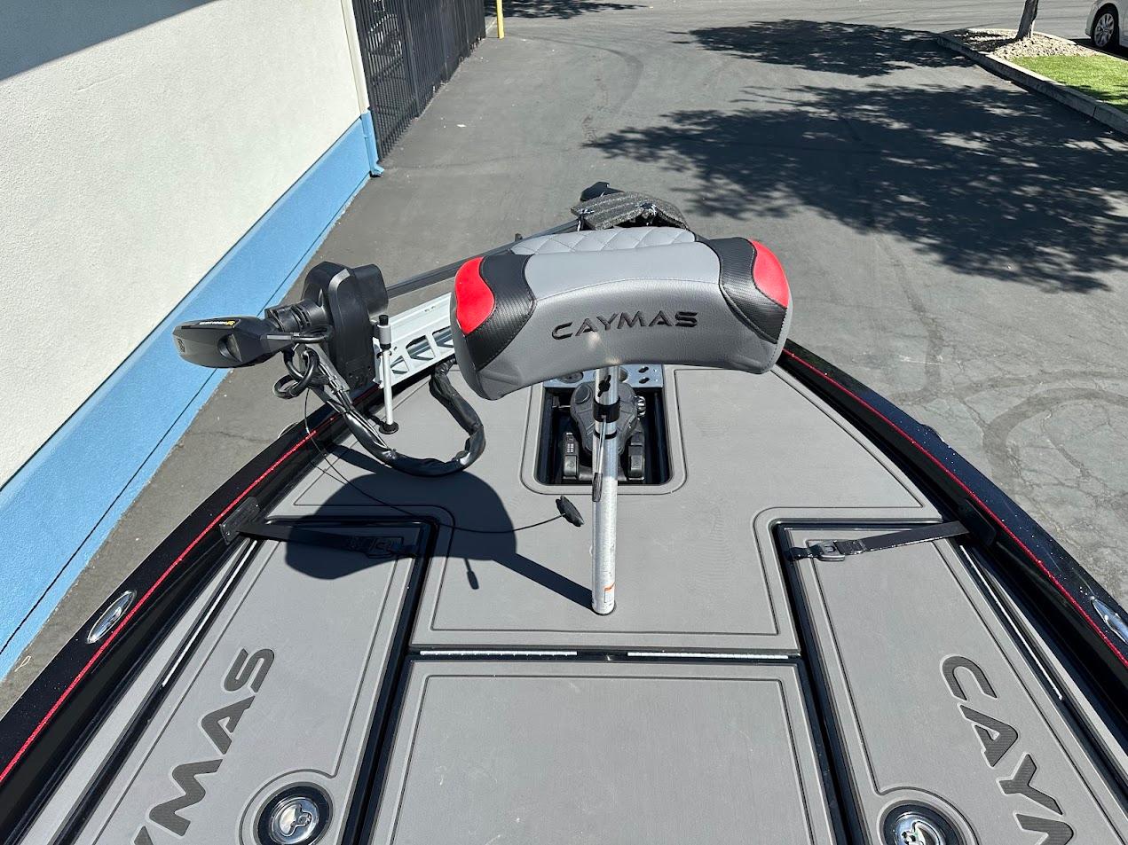 2024 Caymas XS 20 boat deck with seat and trolling motor, parked outdoors.
