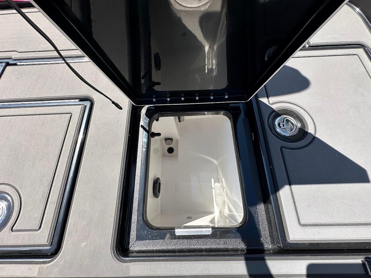 Open storage compartment on 2024 Caymas XS 20 boat deck.
