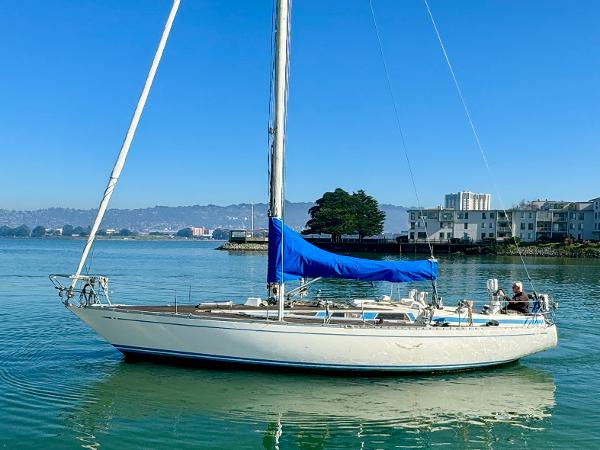 1974 Nautor Swan 38 sailboat with blue sail cover on calm water.
