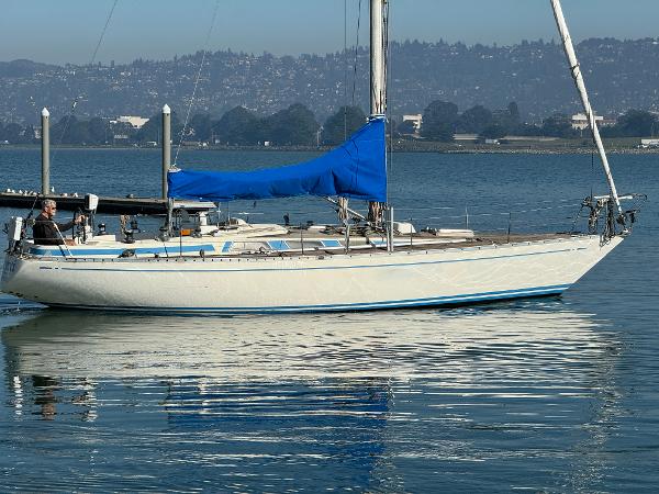 1974 Nautor Swan 38 sailboat with blue sail cover on calm water.