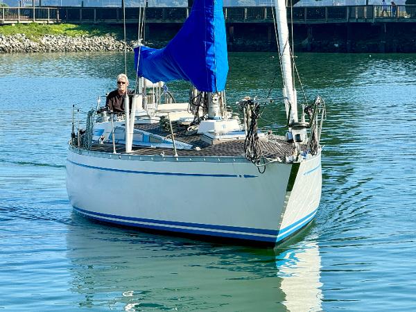 Sailing yacht Nautor Swan 38, 1974 model, cruising on calm waters with blue sail.