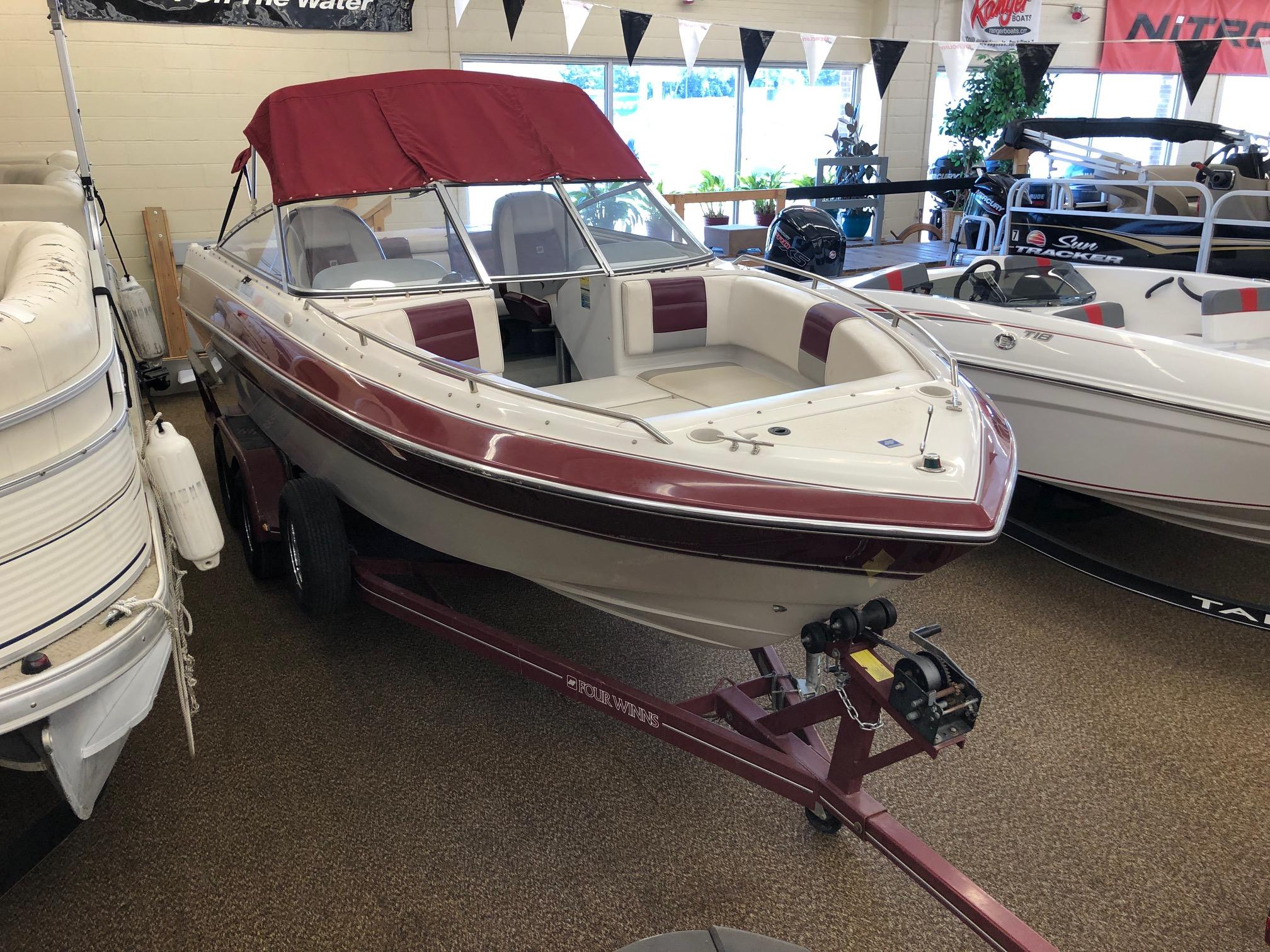 1992 Four Winns 220 Horizon Open Bow boat with maroon and white interior on display.