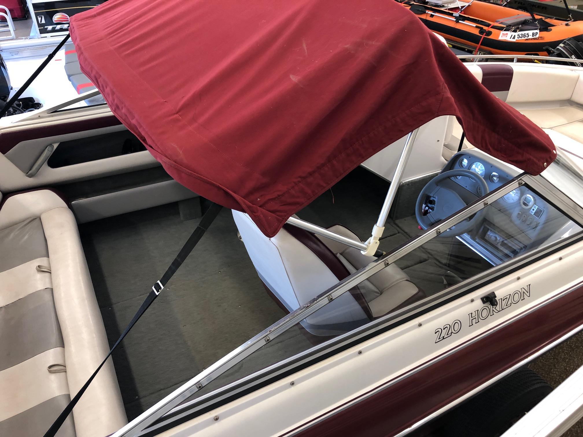 1992 Four Winns 220 Horizon Open Bow boat with red canopy and beige interior.