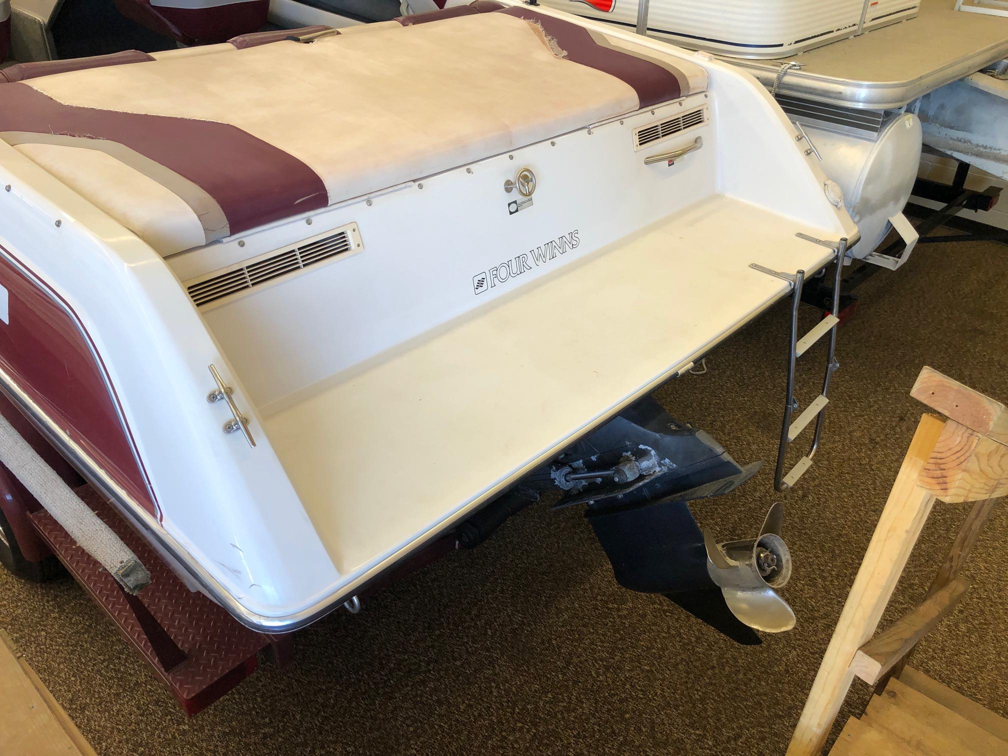 1992 Four Winns 220 Horizon Open Bow boat rear view with swim platform and ladder.