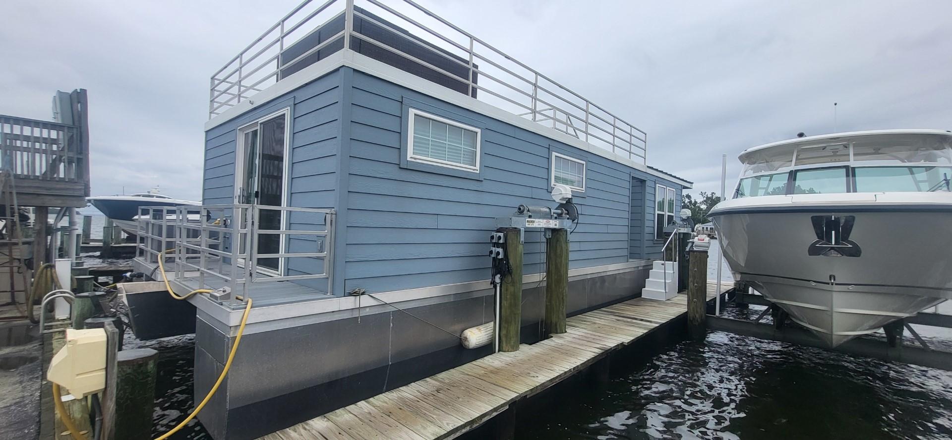Destination Yachts-16x45 Condo Series 2020 -FL-US-2020 Destination Yachts 16x45 Condo Series houseboat docked beside a yacht.-9562403 | Thumbnail