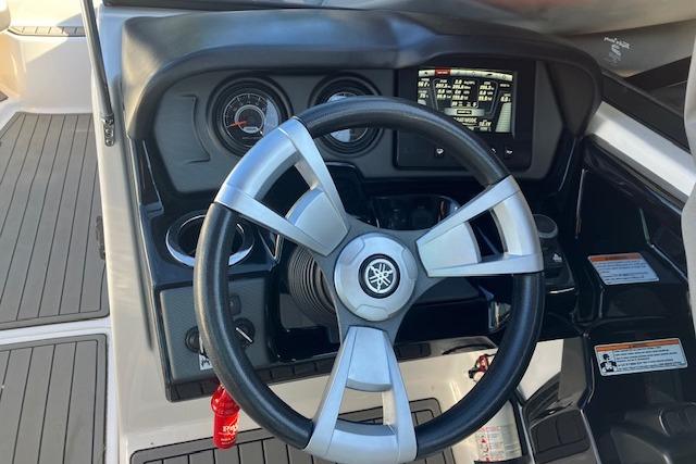 Steering wheel and dashboard of 2016 Yamaha AR240 boat, featuring gauges and controls.